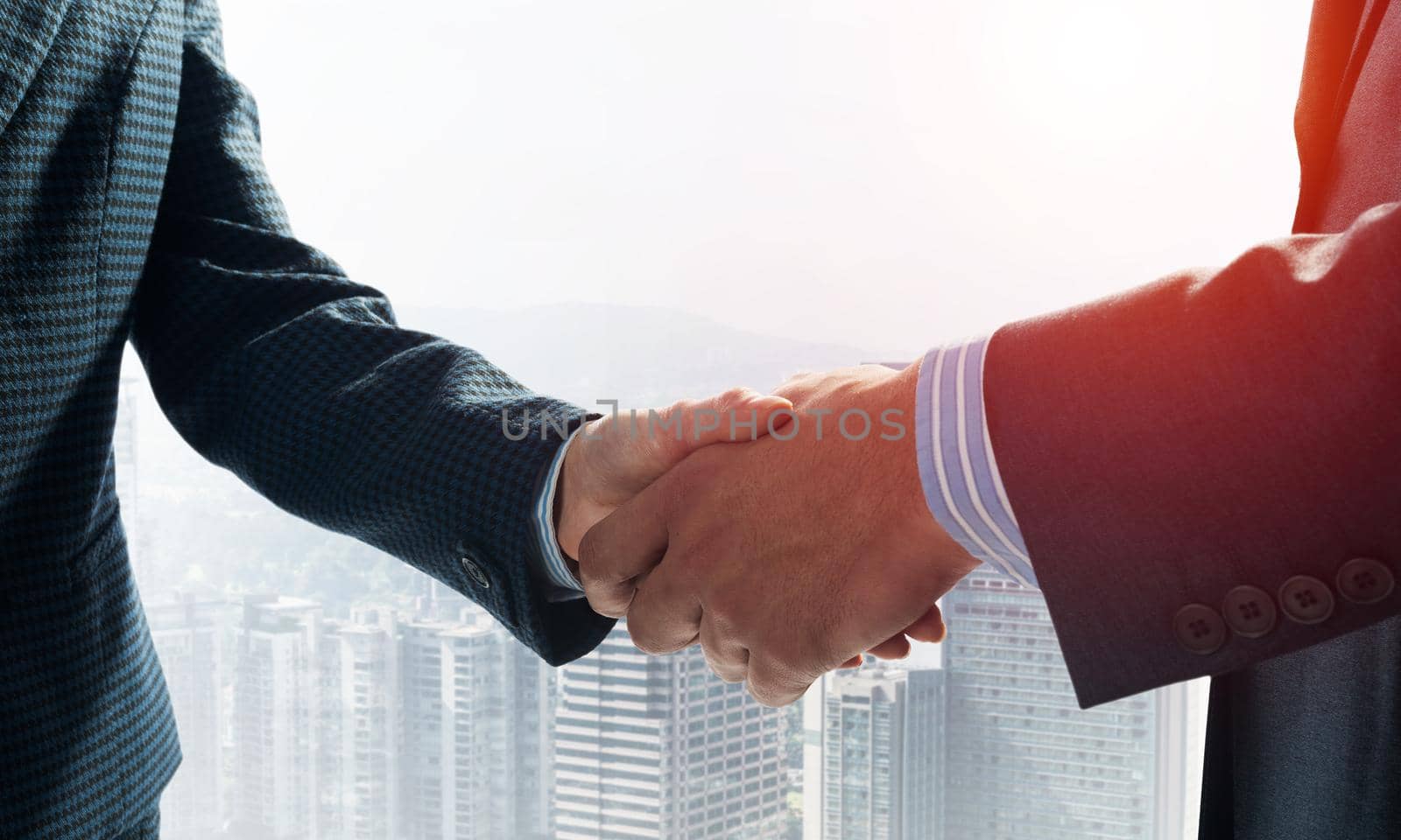 Close-up of the handshake of businessmen. Against the backdrop of the cityscape