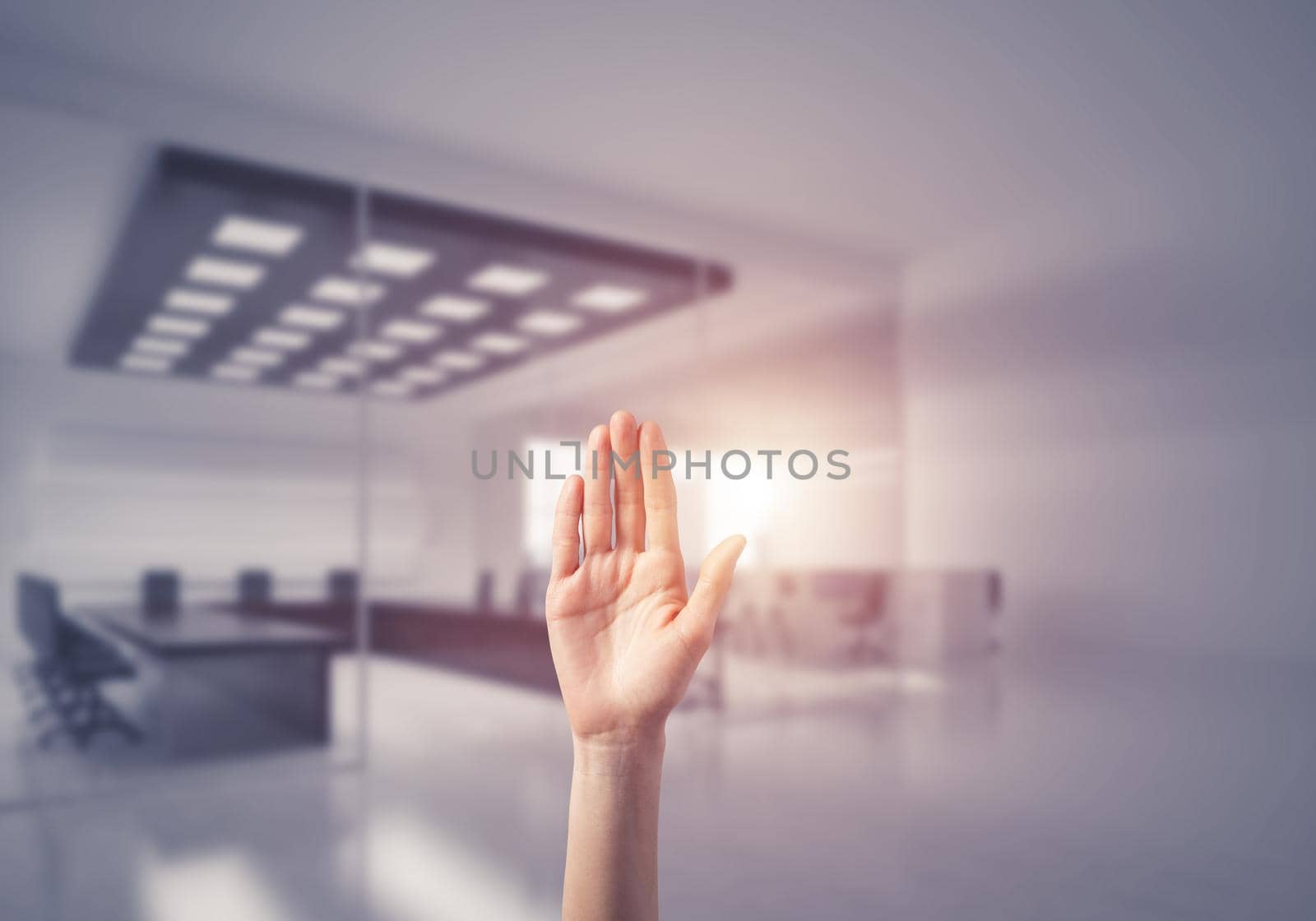 Close of woman hand touching screen with palm and office at background
