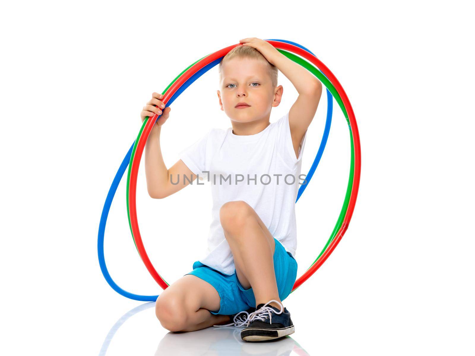 Cute little boy playing with a hoop. Concepts of fitness, children's sports. Isolated on white background.