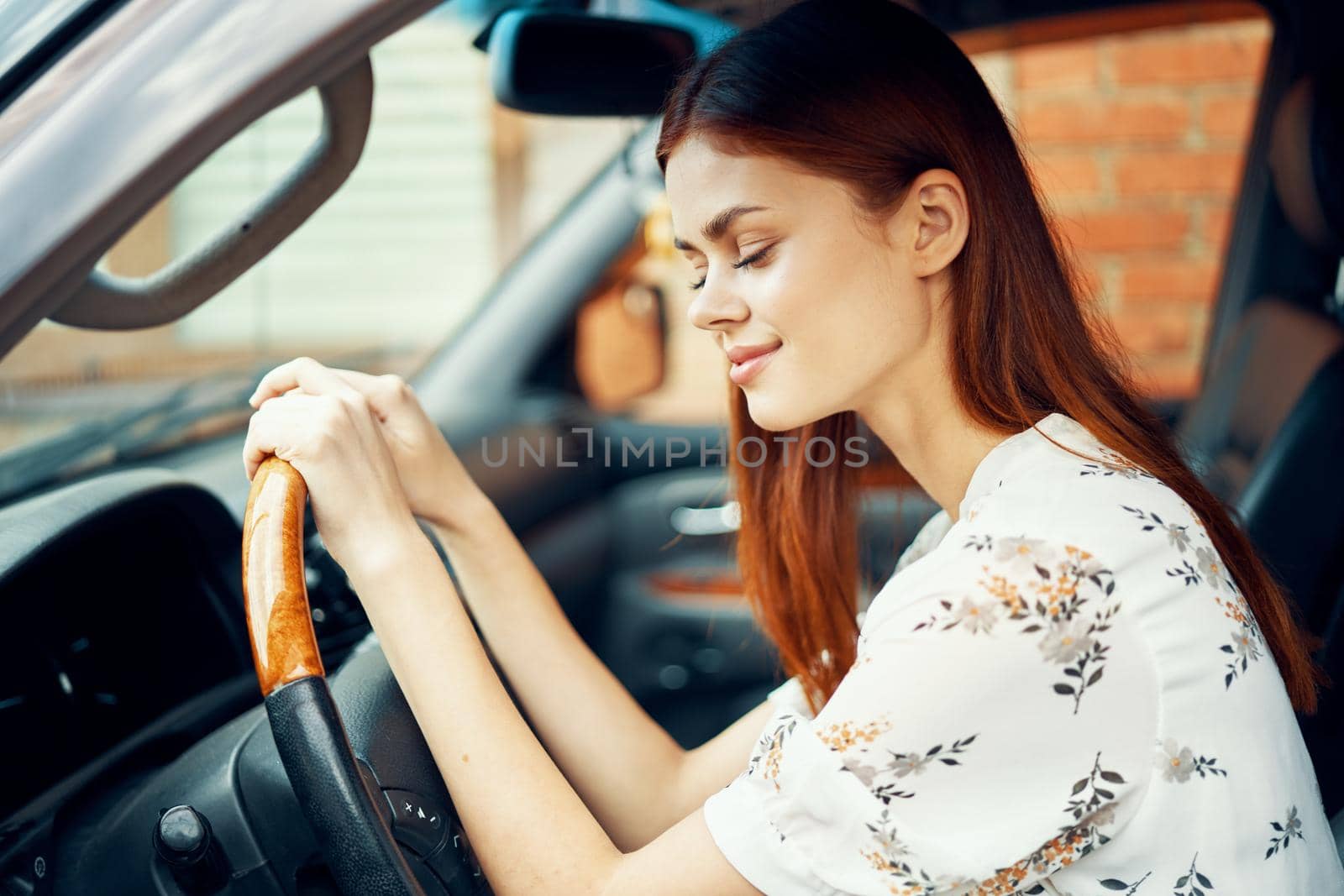 cute red-haired woman driving a car lifestyle trip. High quality photo