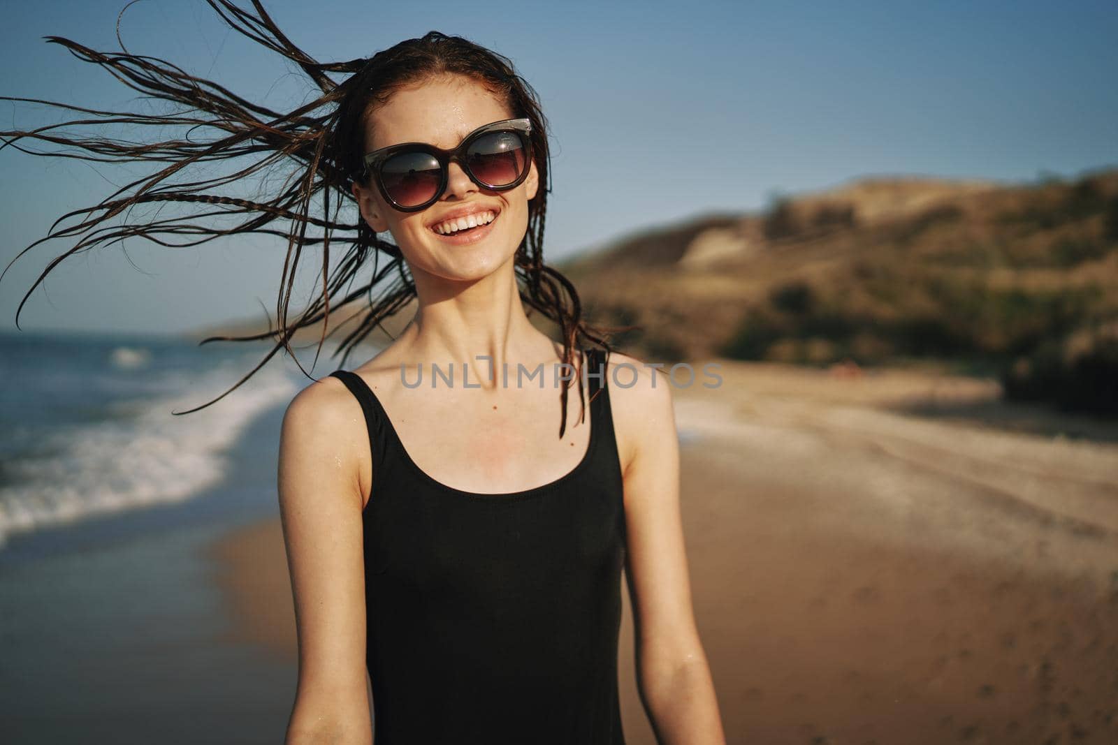 woman walks along the sandy shore in a black swimsuit sun tropics. High quality photo