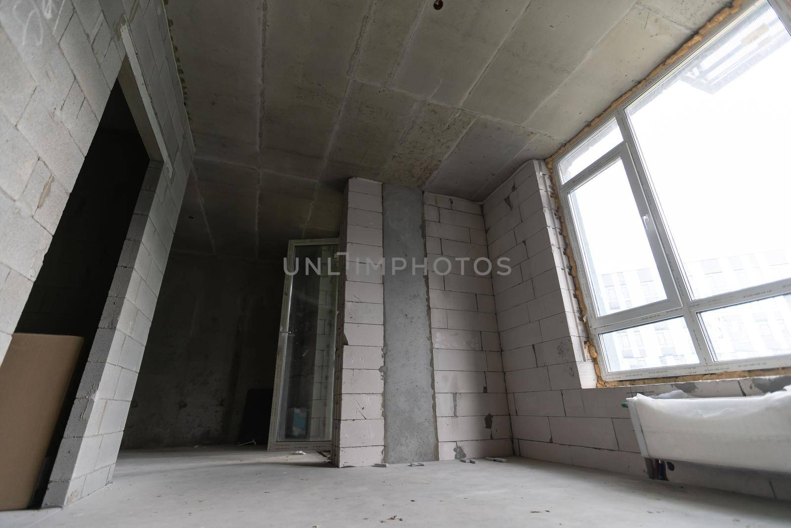 Small apartment without repair in a new building. A room in an unfinished house. Walls of foam block and concrete floor in a tiny apartment.