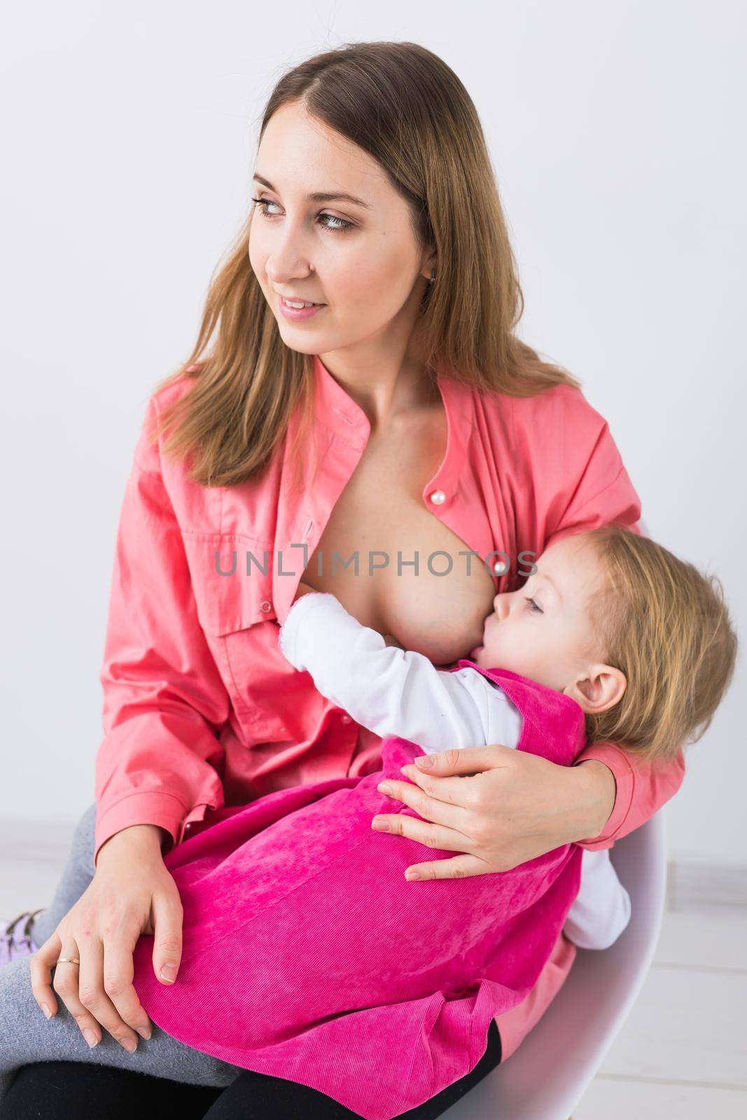 Motherhood and family concept - mother breast feeding and hugging her baby. by Satura86