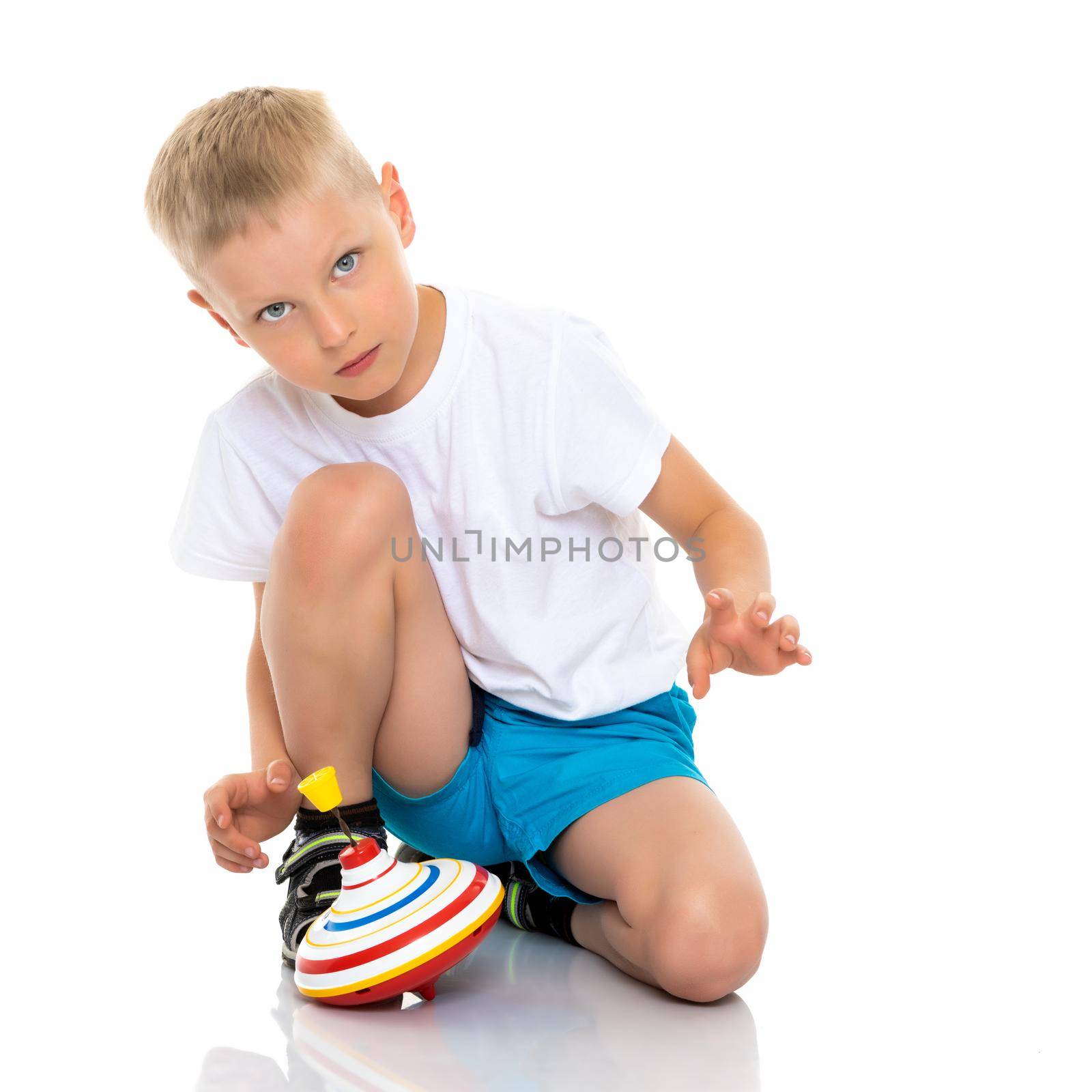 Little boy playing with a whirligig. Isolated on white background.