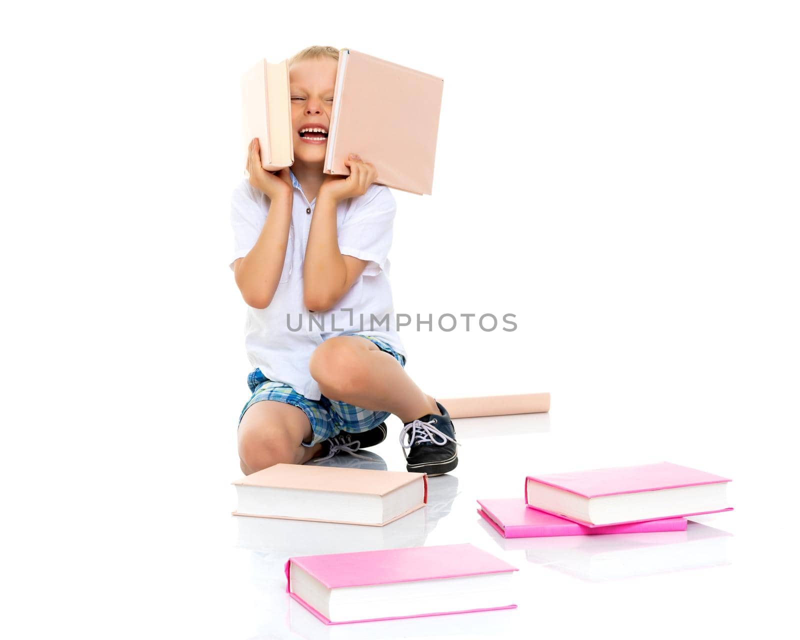 A cute little boy, a preschooler with books. The concept of education, the intellectual development of the child in the family. Isolated on white background.