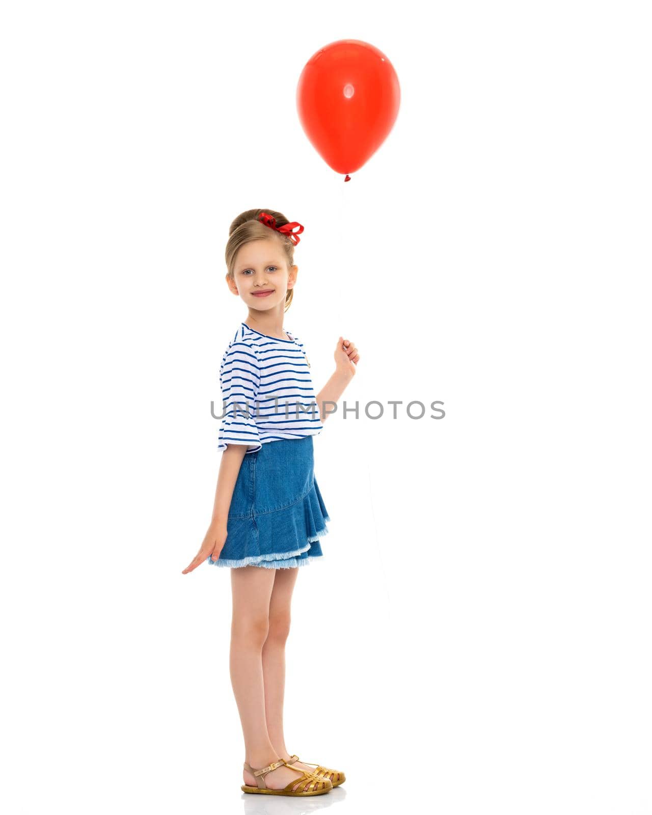 Little girl is playing with a balloon. The concept of the holiday, birthday. Isolated over white background