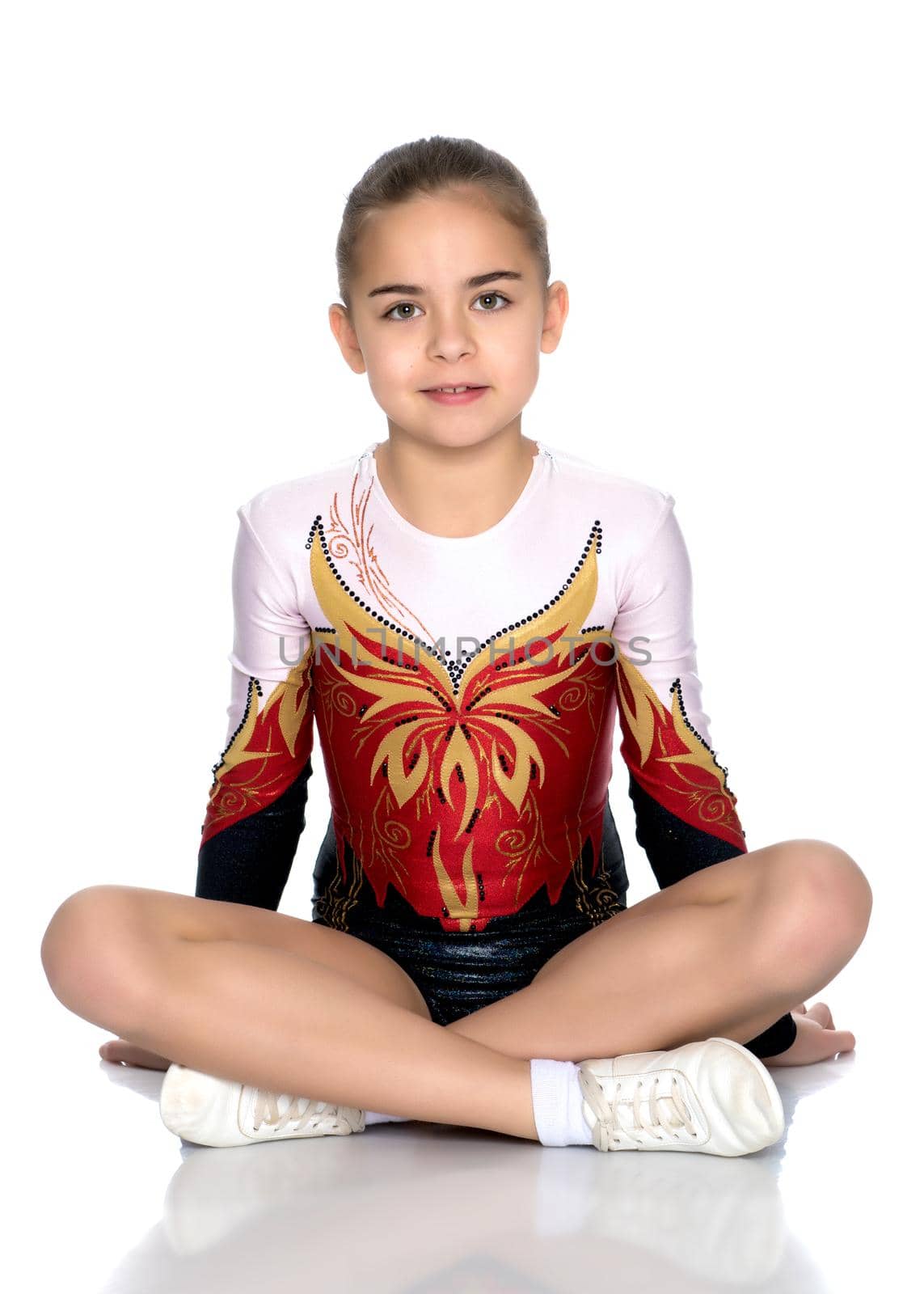 A gymnast girl prepares for the exercise. The concept of childhood and sport, a healthy lifestyle. Isolated on white background.