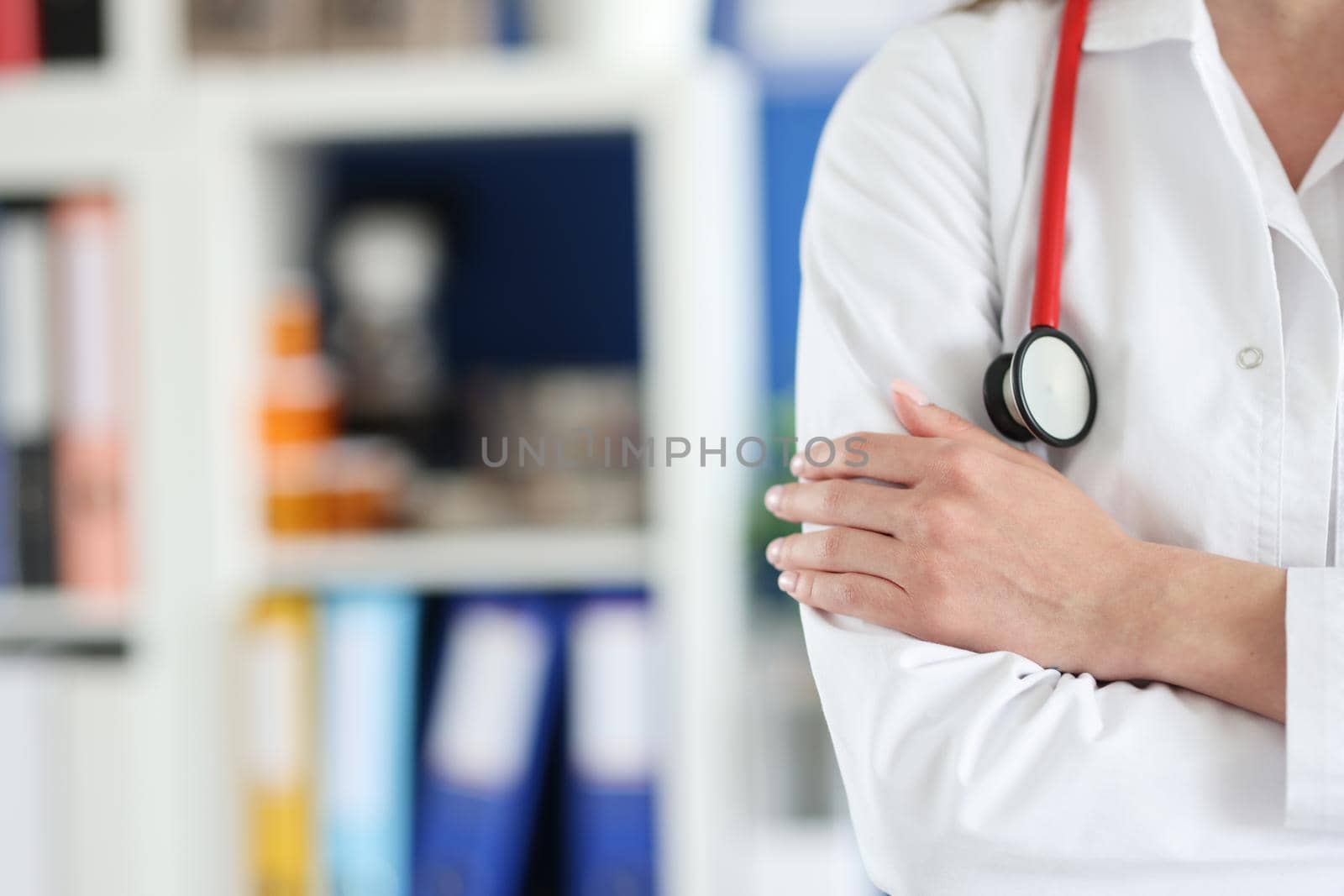 Woman doctor in uniform folded her arms over her chest close-up, blurry. Preparedness of medical personnel for a pandemic