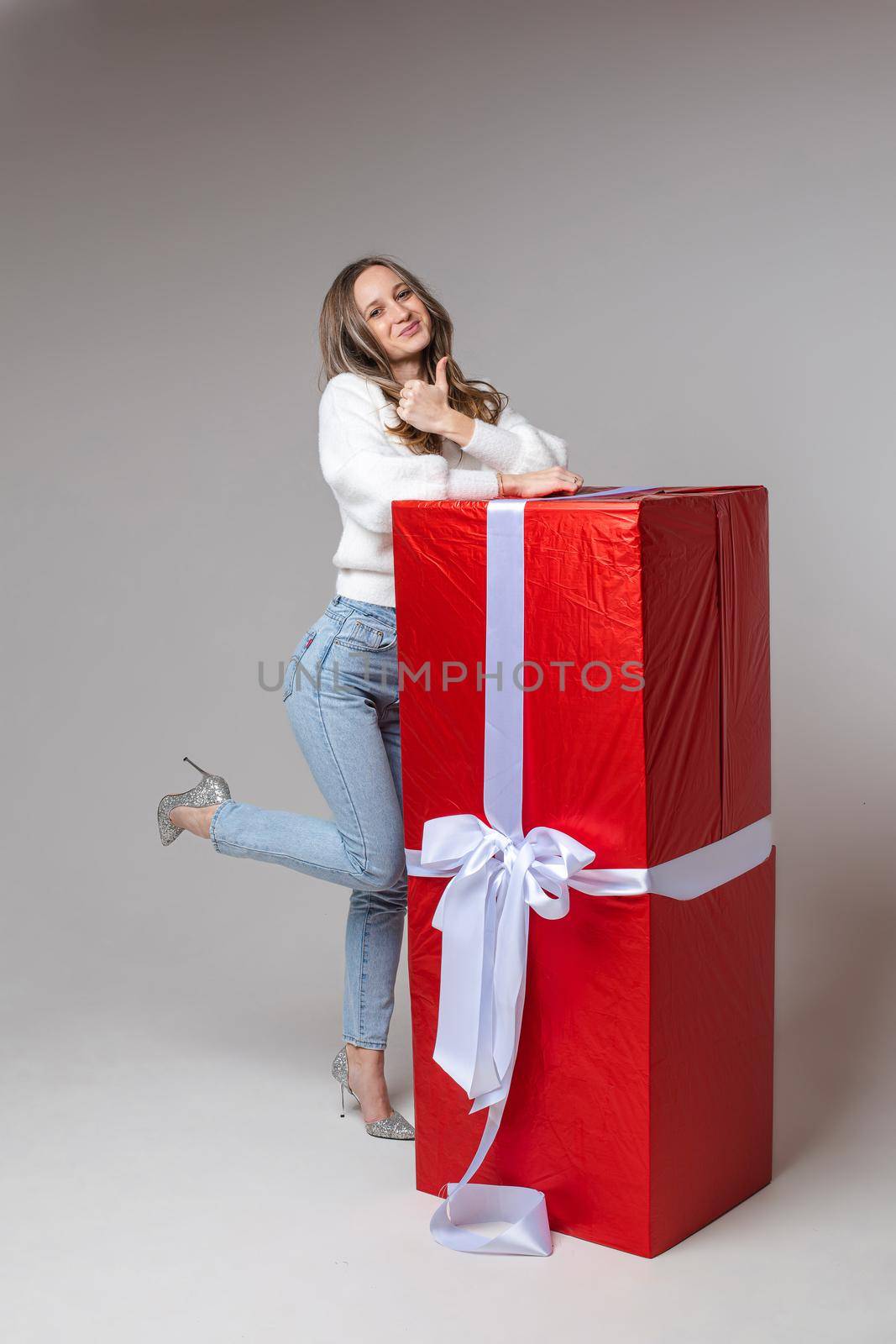 beautiful female model poses for the camera with a big red box with her christmas present by StudioLucky
