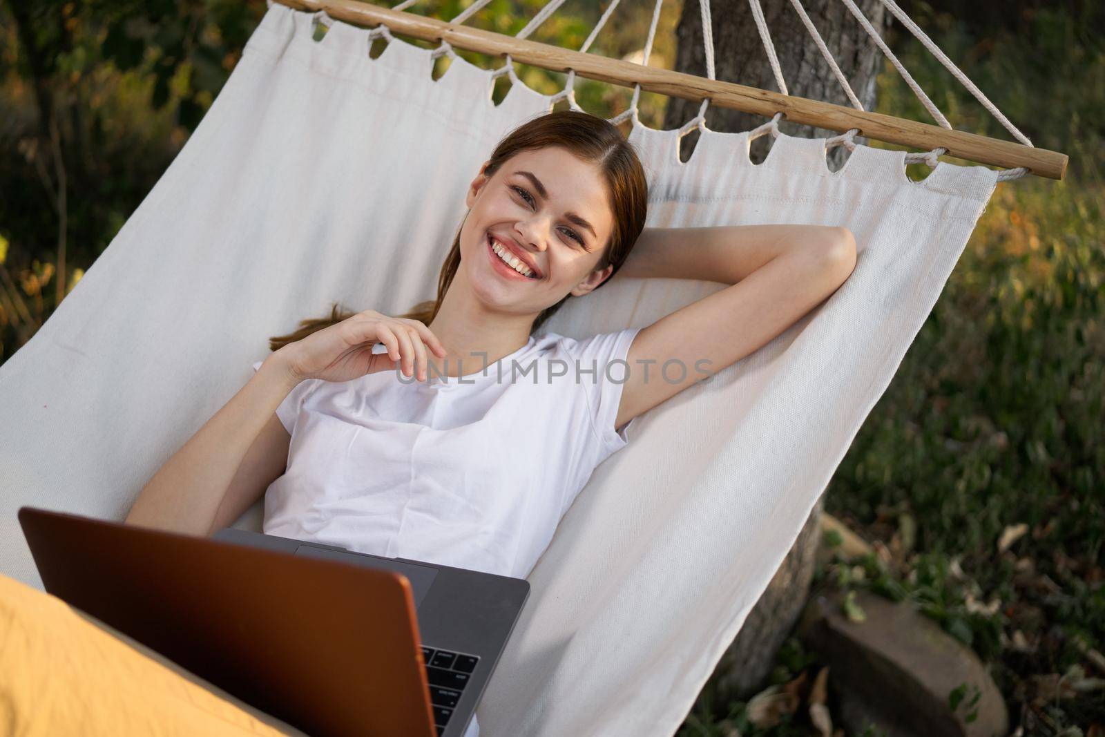 woman working on laptop in nature hammock freelance. High quality photo
