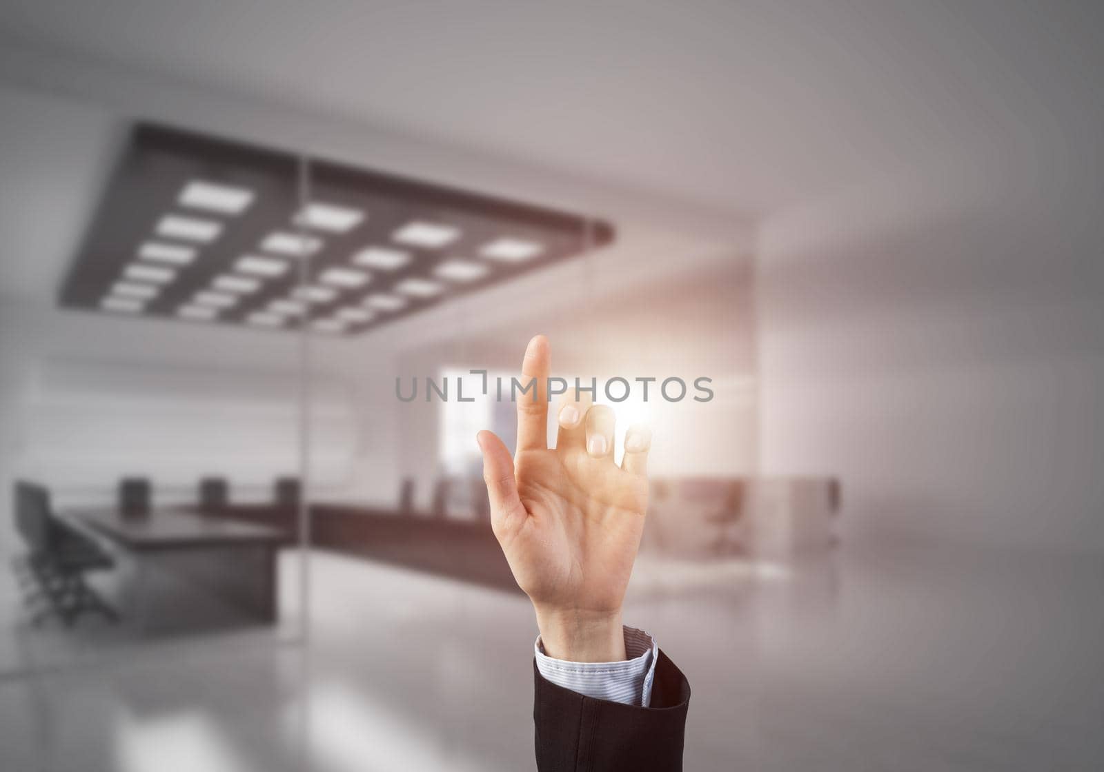 Close of businesswoman hand touching screen with finger and office at background