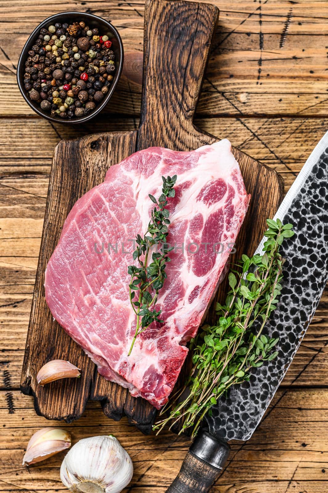 Fresh Raw marble meat pork steaks on a cutting board with knife. wooden background. Top view by Composter