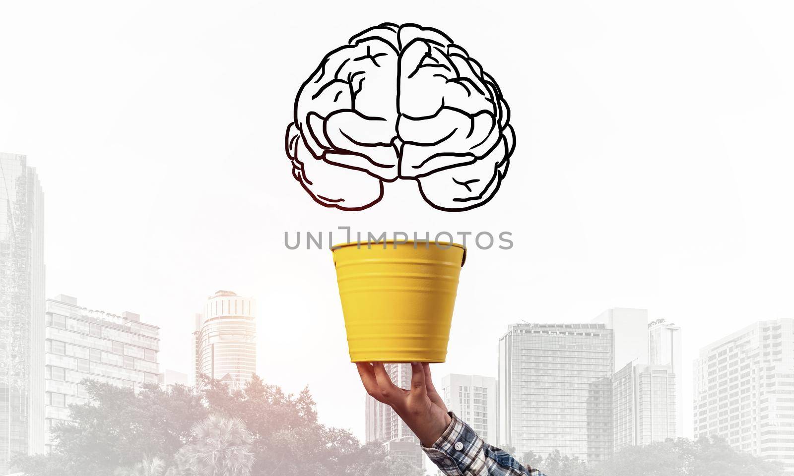Brain drawing flying above yellow pot. Human hand holding pot with brain on modern cityscape background. Brainstorming and creative idea generation. Business education and knowledge.