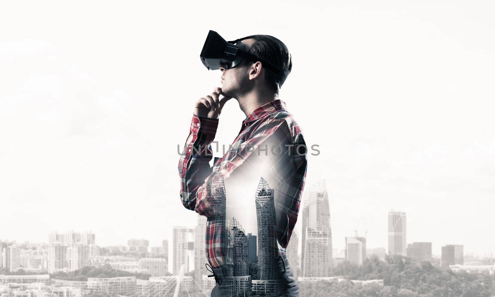 Young man with virtual reality headset or 3d glasses over cityscape background