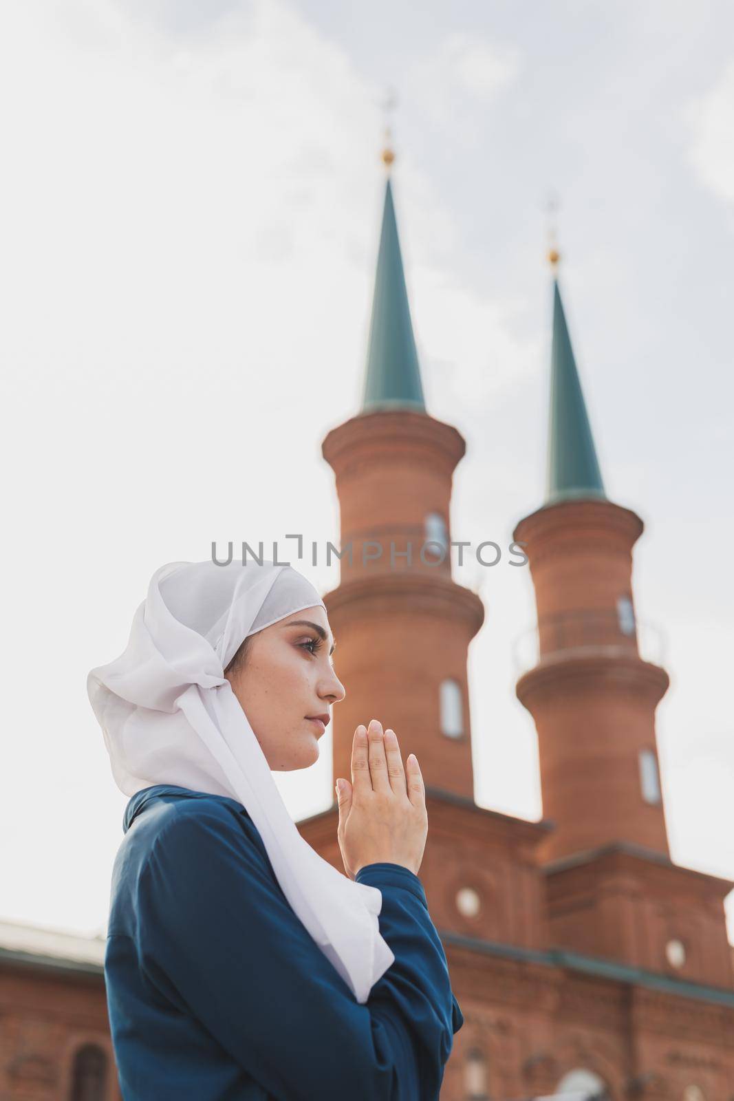 Young Muslim woman prayer wear hijab fasting pray to allah on mosque background