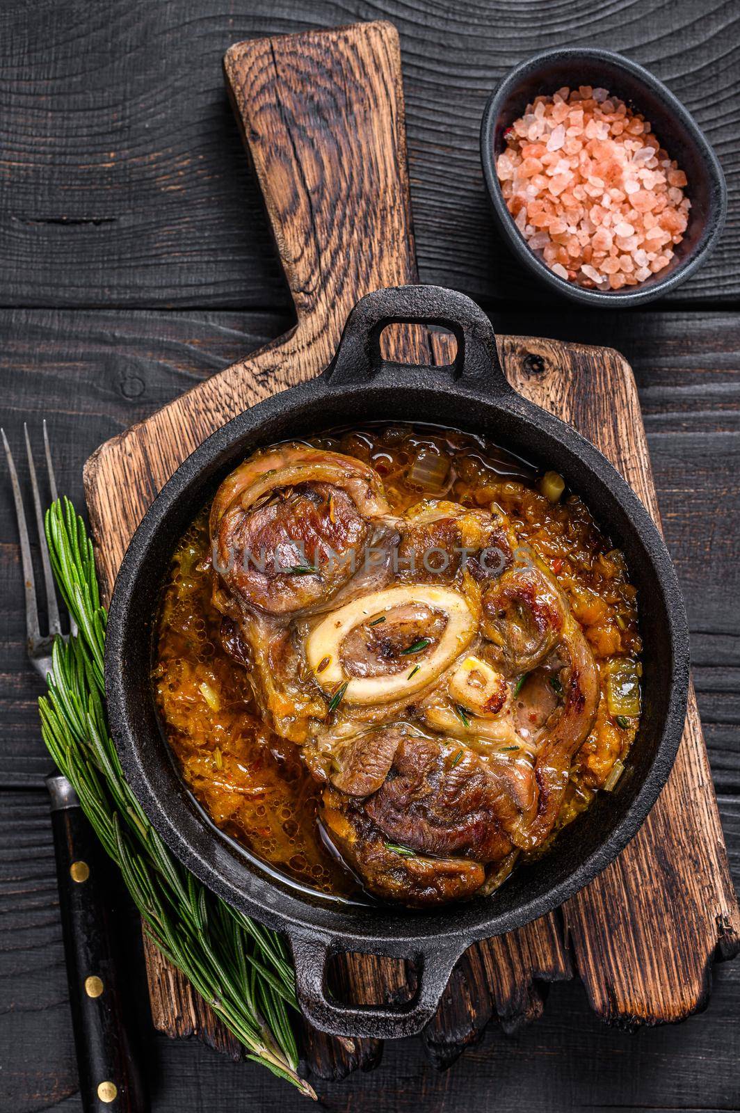 Stew veal shank meat OssoBuco, italian osso buco steak. Black wooden background. Top view by Composter
