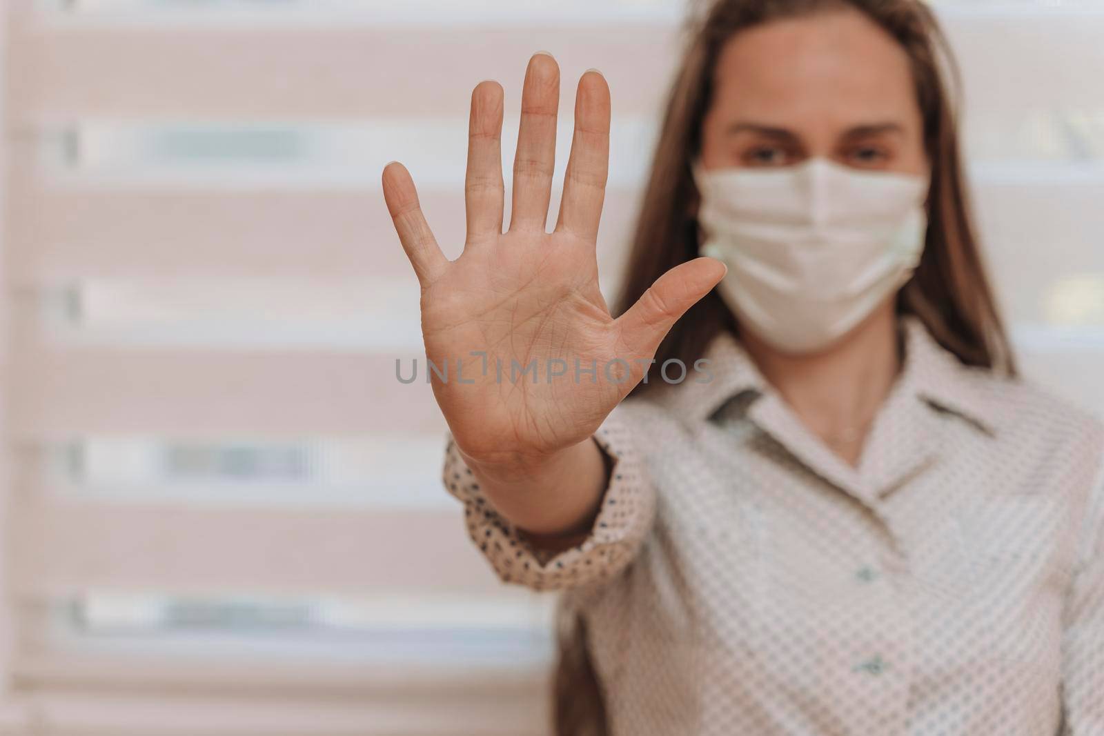 Close-up portrait of a young blonde woman in a medical mask on a light background. Virus protection. Coronovirus covid-19 The concept of a pandemic epidemic. Quarantine. Stay at home