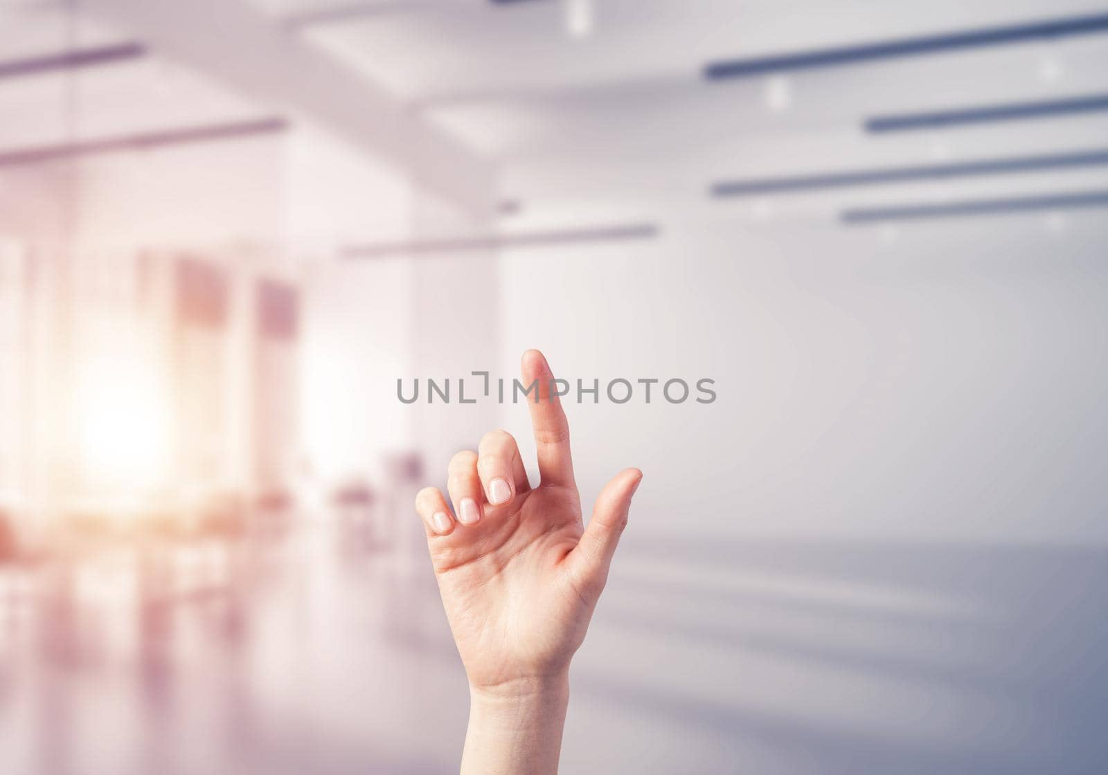 Close of woman hand touching screen with finger and office at background