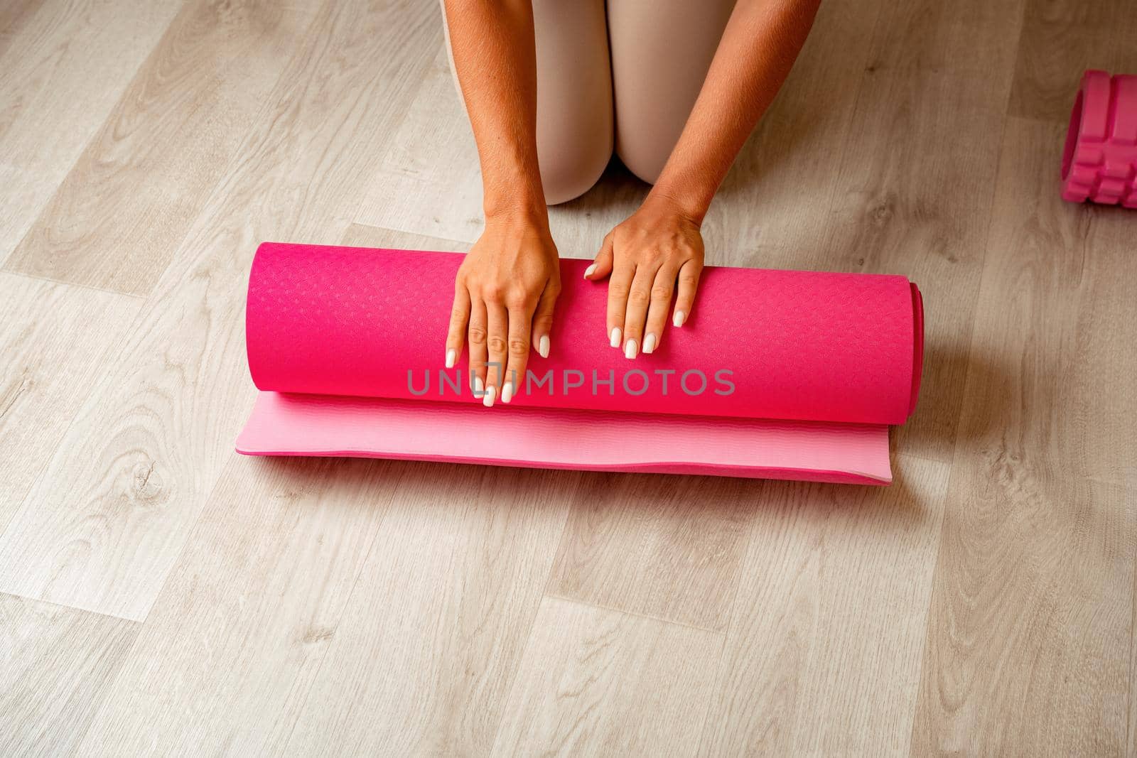 Young woman with long hair, fitness instructor in black sportswear, doing stretching and pilates on yoga mat at home. Female fitness yoga routine concept. Healthy lifestyle harmony and meditation