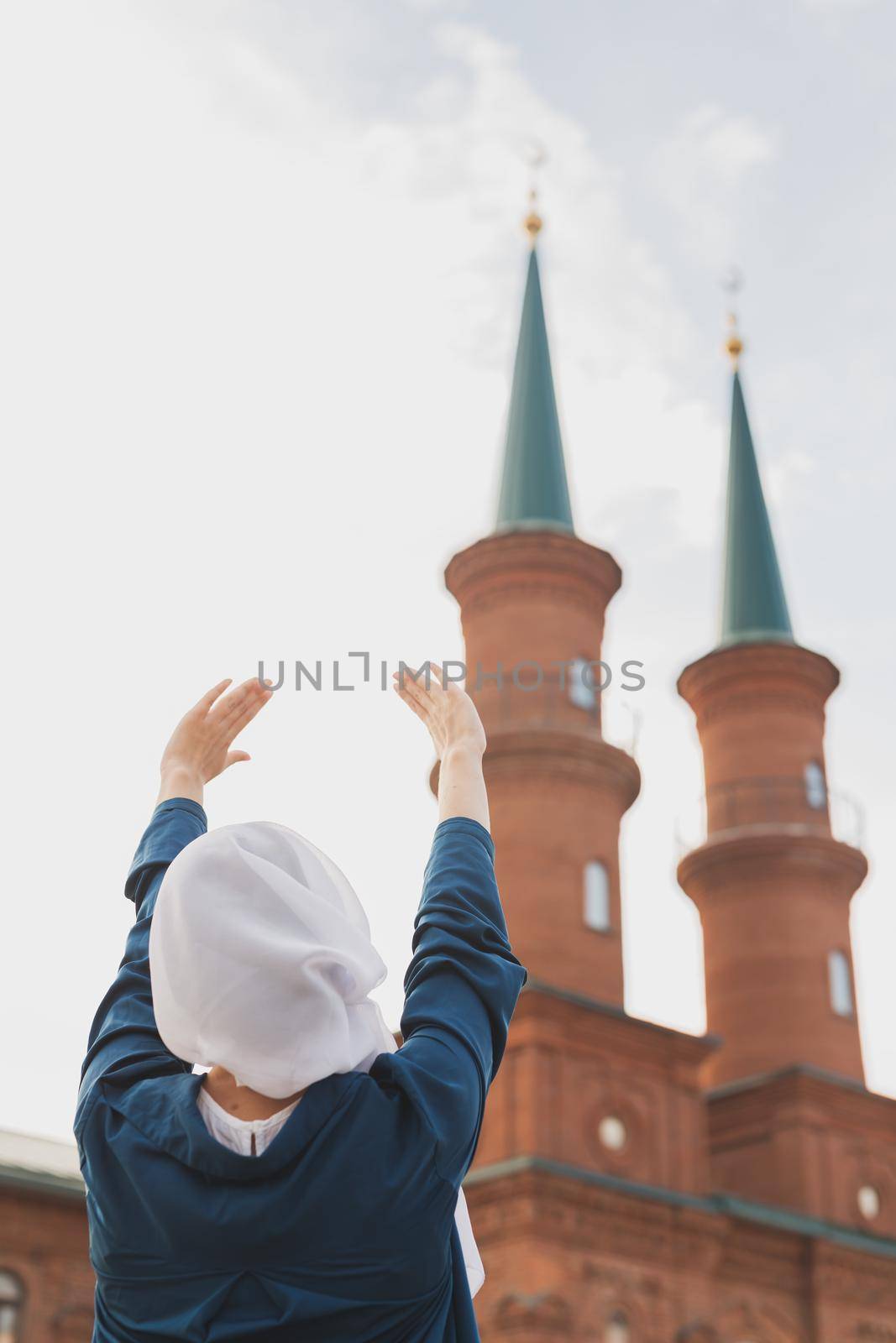 Young Muslim woman prayer wear hijab fasting pray to allah on mosque background