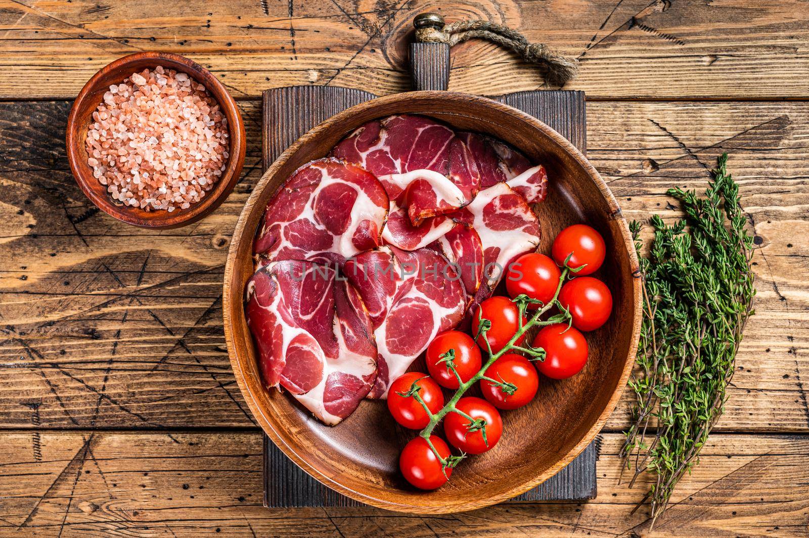 Italian sliced cured coppa ham with spices. wooden background. Top view.