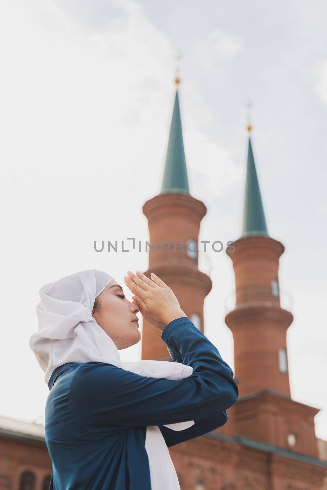 Young Muslim woman prayer wear hijab fasting pray to allah on mosque background