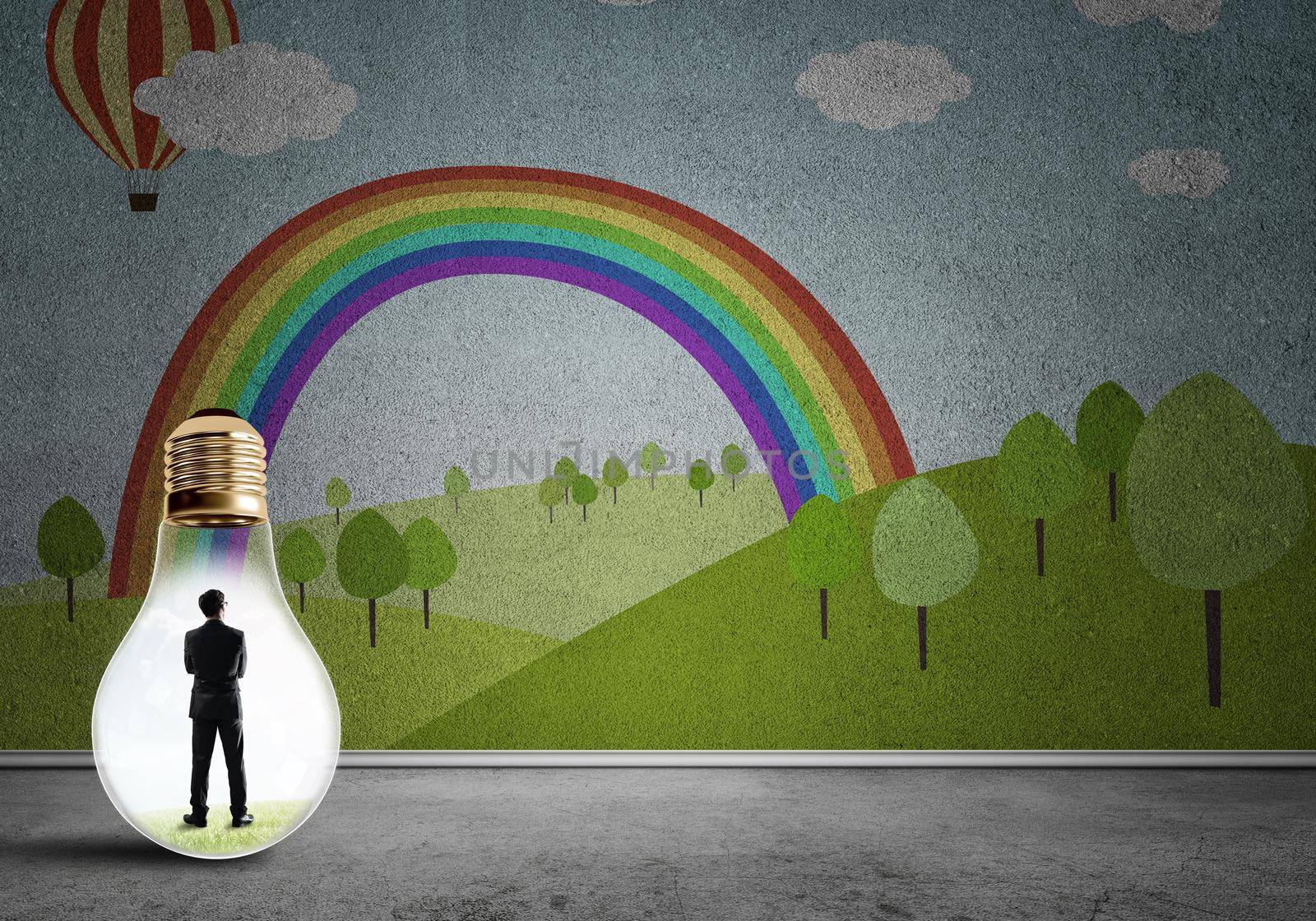 Businessman inside light bulb in room against nature drawn concept