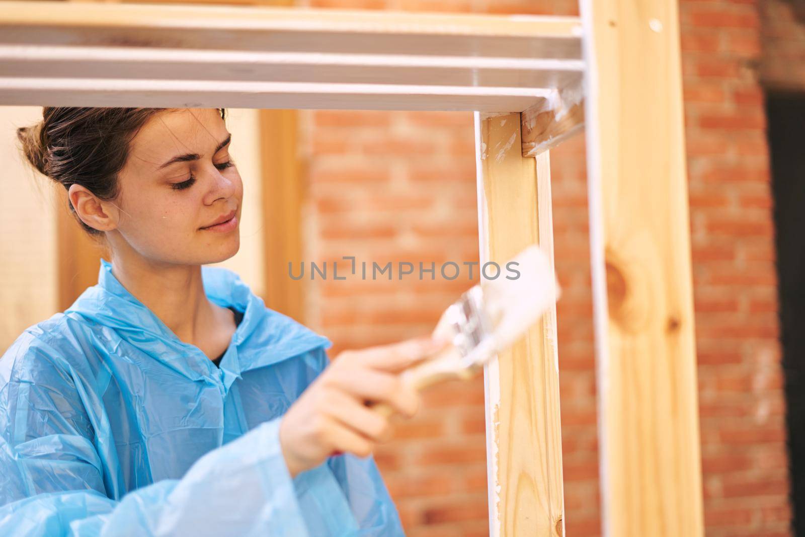 cheerful woman house painter repairing wooden structure by Vichizh