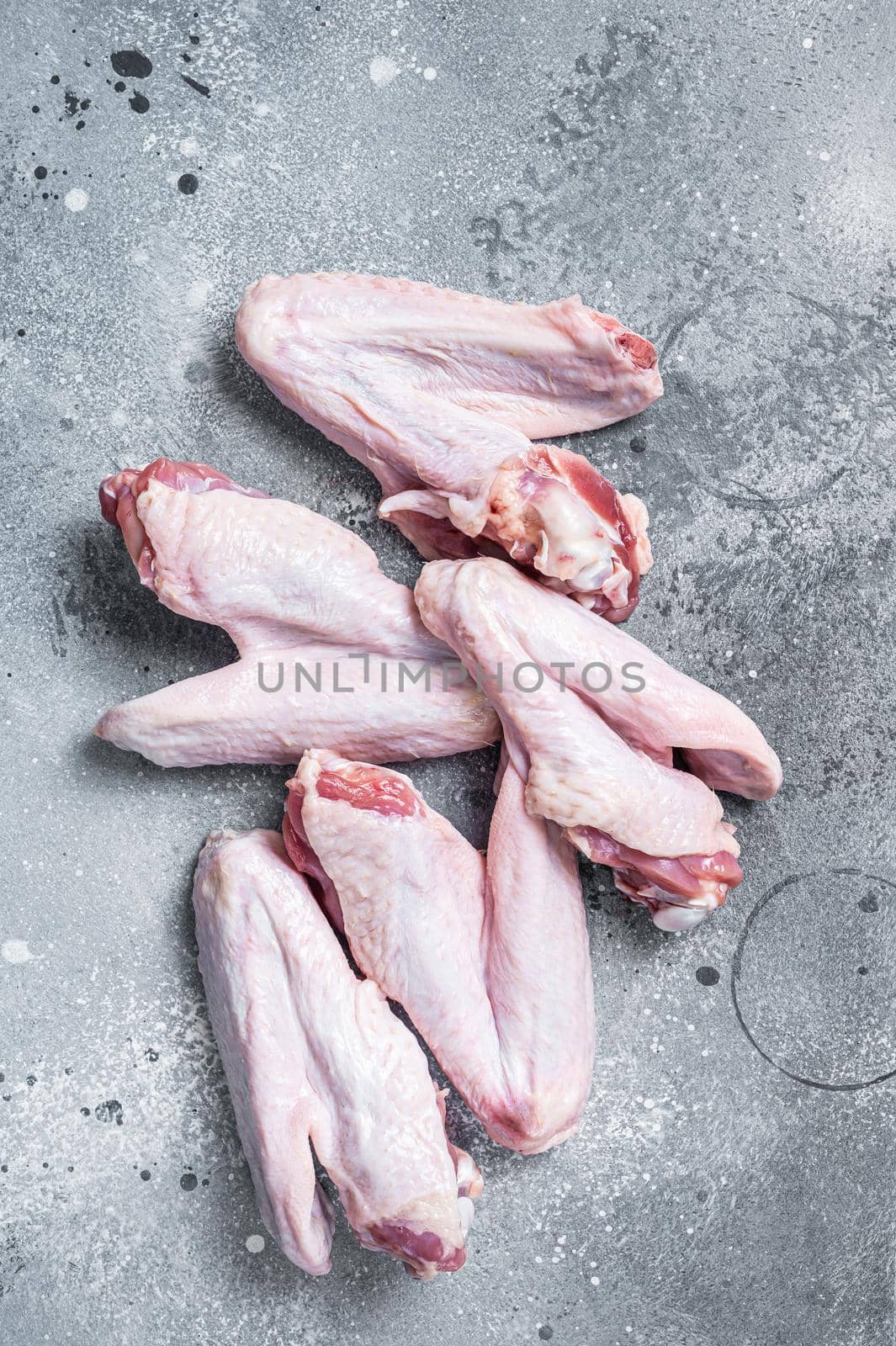 Fresh raw duck wings on kitchen table. Gray background. Top view.