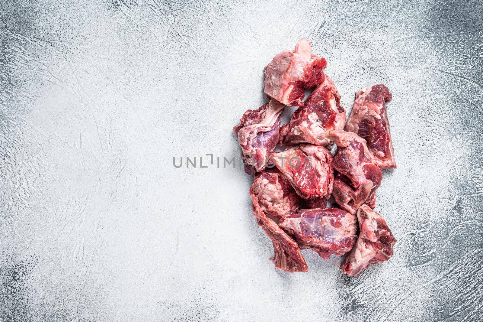 Raw lamb meat stew cuts with bone. White background. Top view. Copy space.