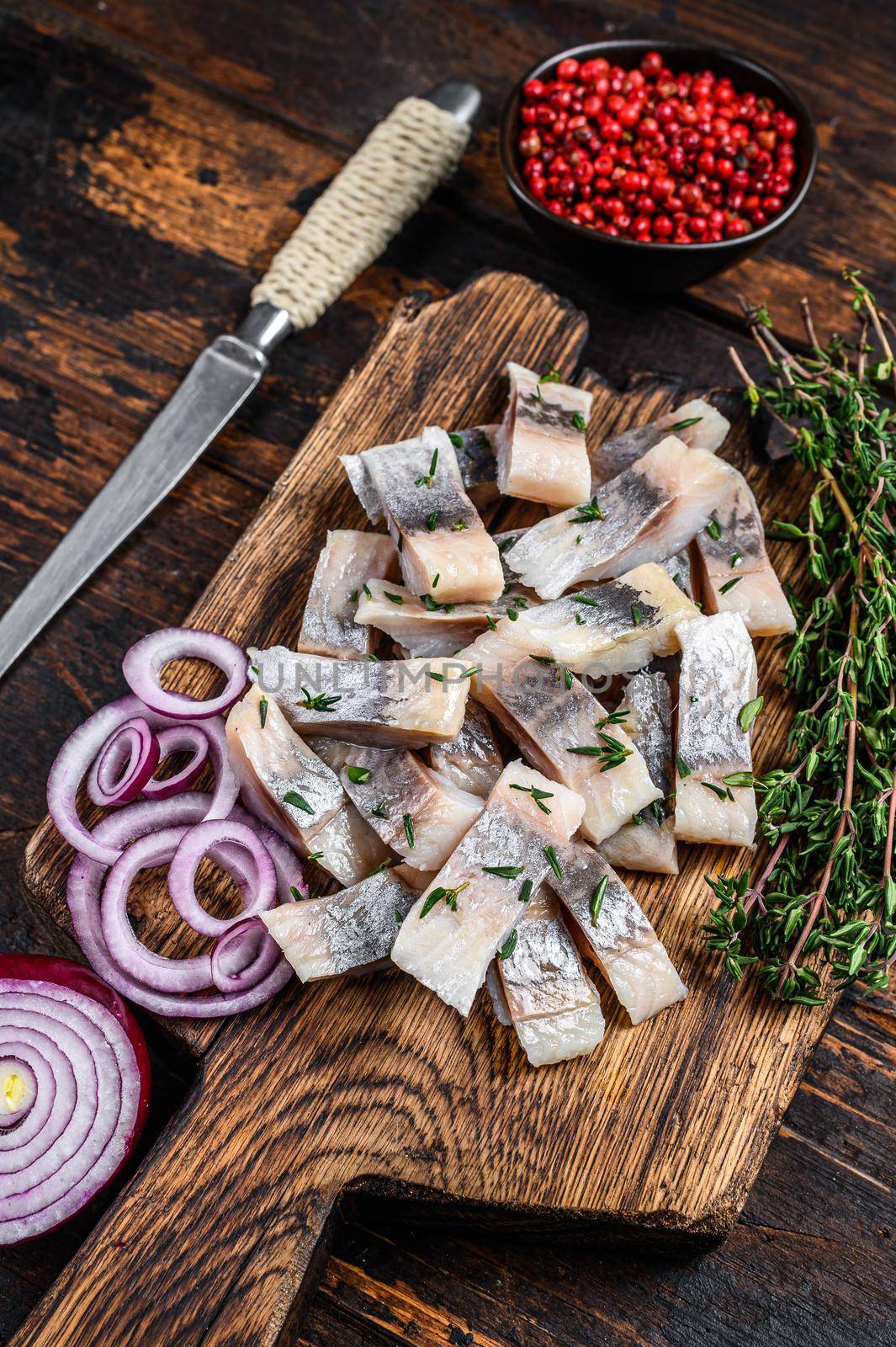 Pickled marinated herring fish sliced fillet. wooden background. Top view. Copy space.