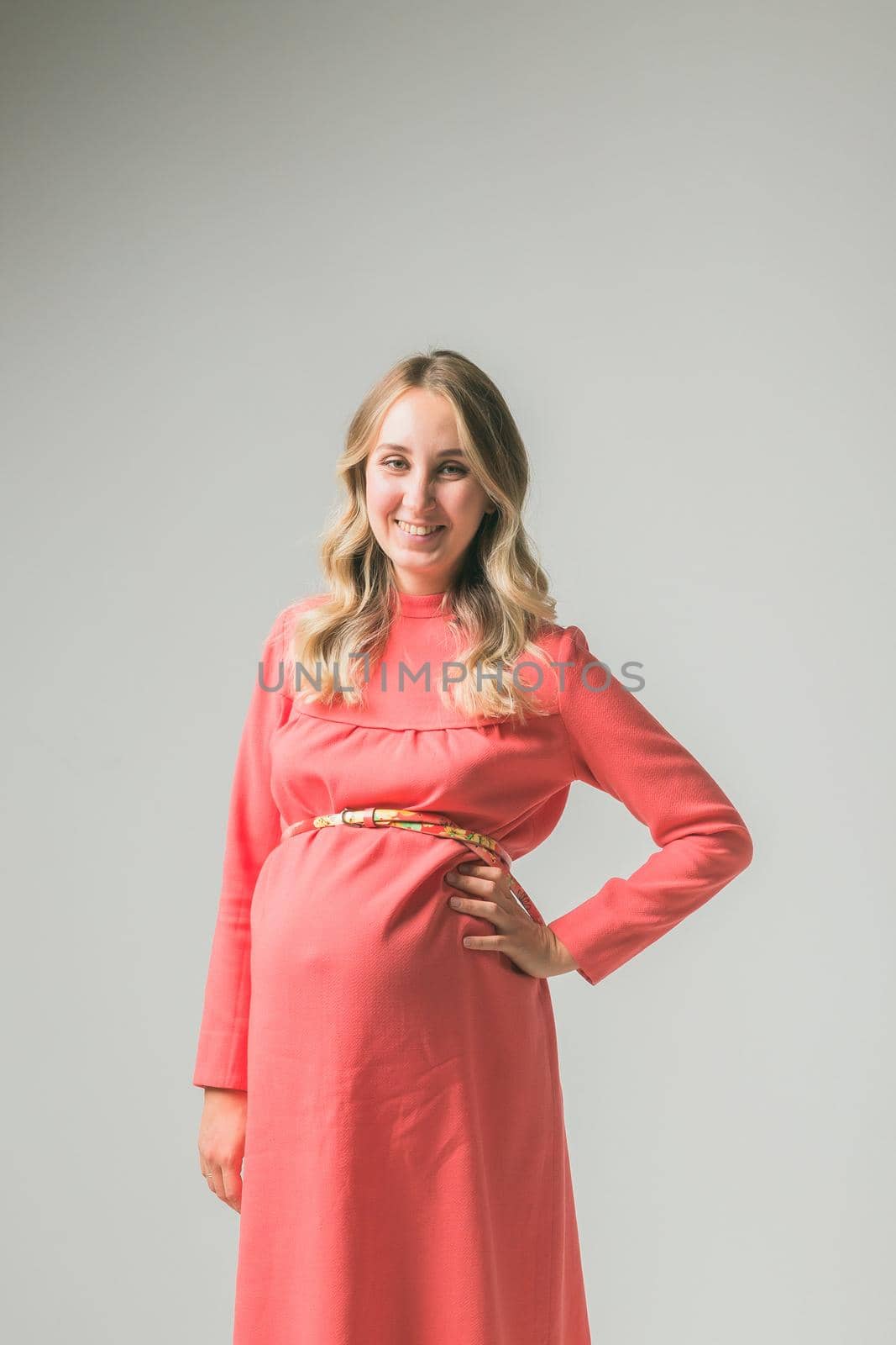Pregnant woman on white wall background