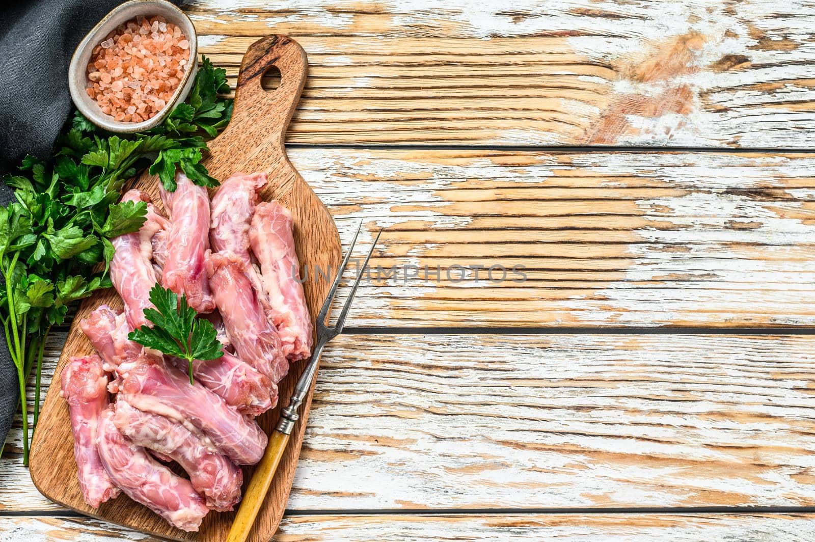 Raw Chicken neck meat, offals. White Wooden background. Top view. Copy space.