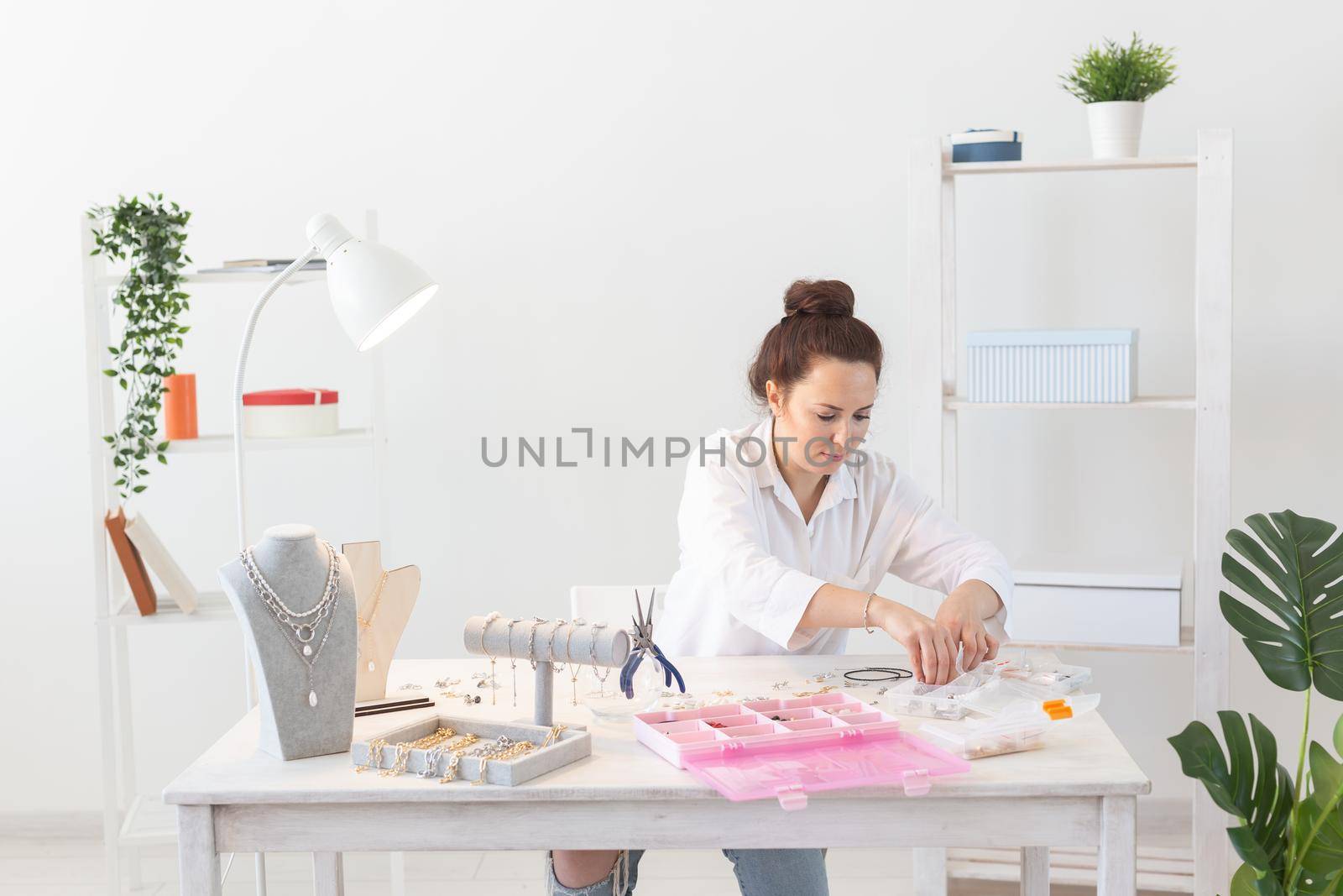 Professional jewelry designer making handmade jewelry in studio workshop. Fashion, creativity and handmade concept.