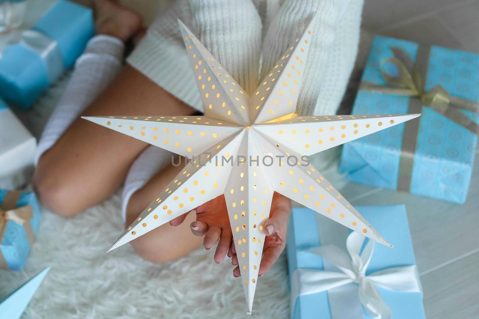 Beautiful caucasian woman is unwrapping the gift box. Celebrating New Year and Christmas, winter holidays. by ElenaBatkova