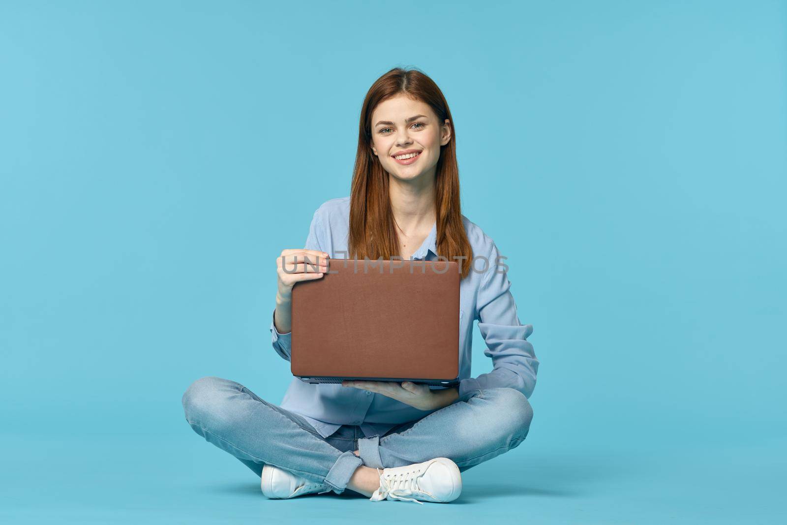 woman with laptop learning internet online education blue background. High quality photo