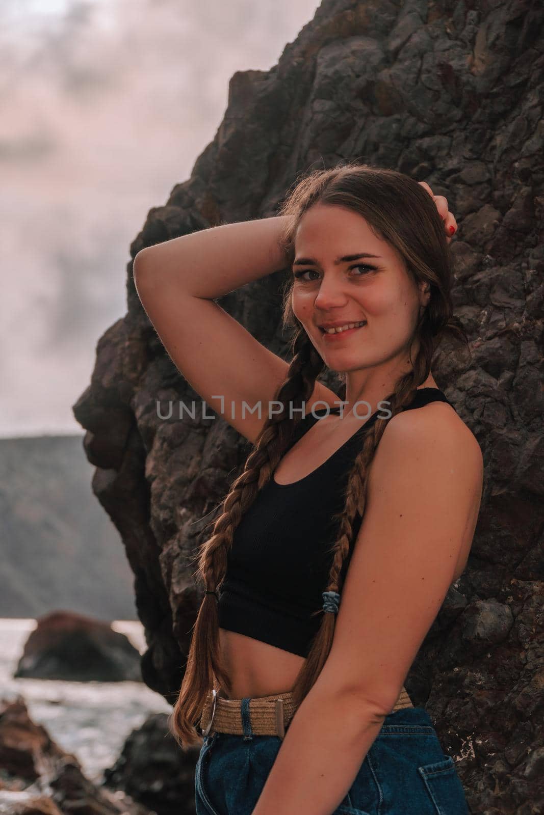 Selective focus. Happy carefree sensual woman with long hair in black swimwear posing at sunset beach. Silhouette of young beautiful playful positive woman outdoor. Summer vacation and trip concept.