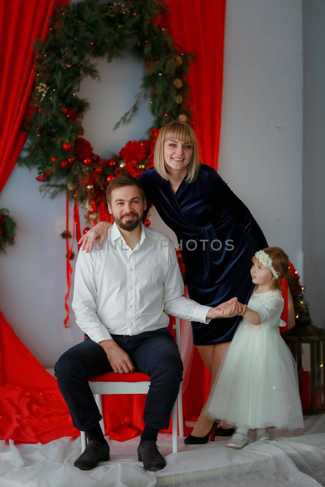 Family photo in red bright scenery a man dressed in a white shirt and a woman in a beautiful dress by ElenaBatkova