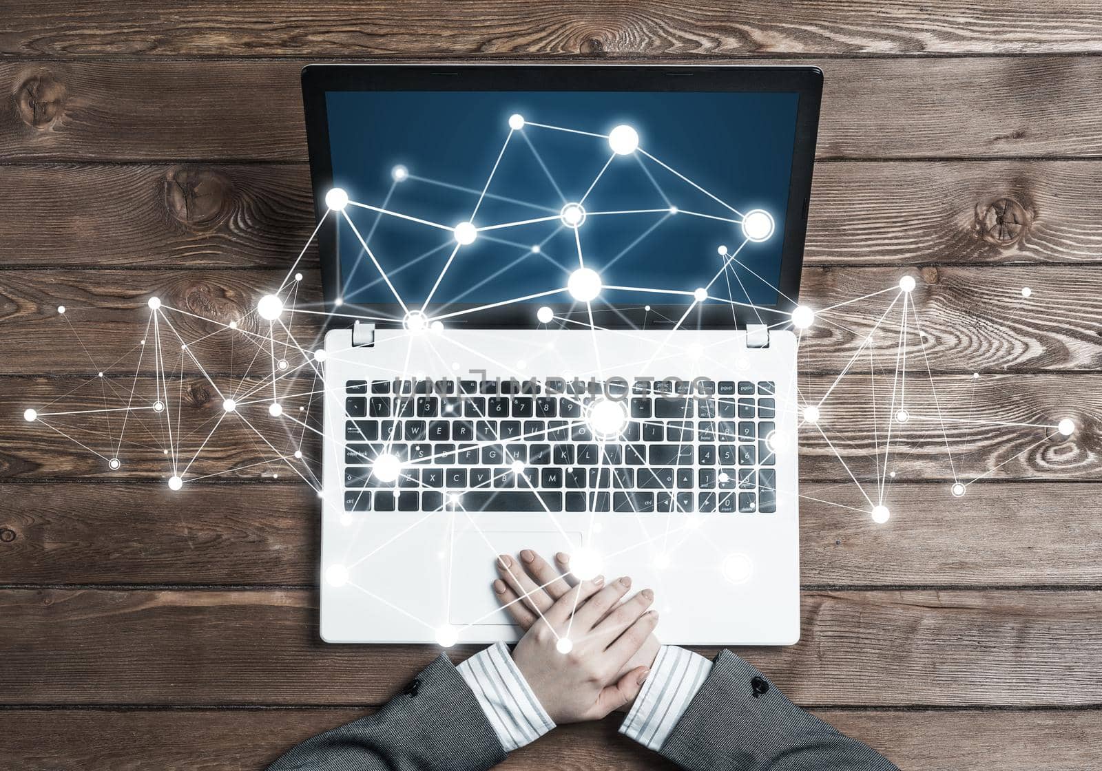 Top view of laptop on wooden surface and businesswoman hands