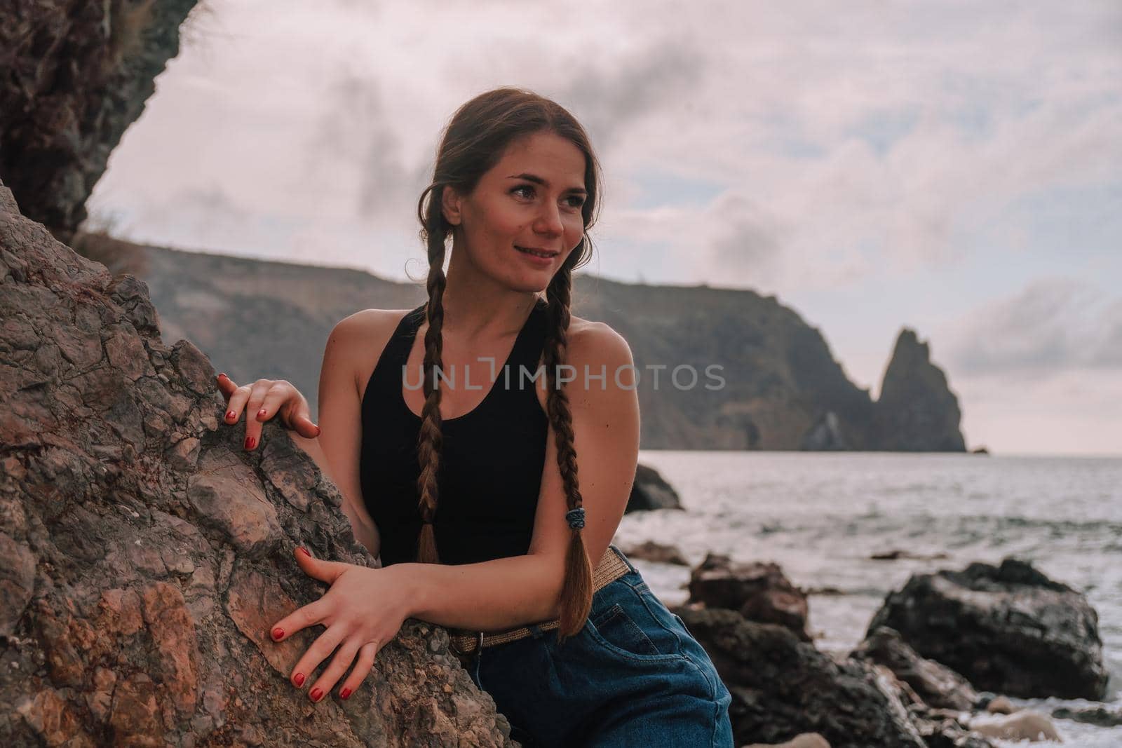 Selective focus. Happy carefree sensual woman with long hair in black swimwear posing at sunset beach. Silhouette of young beautiful playful positive woman outdoor. Summer vacation and trip concept.
