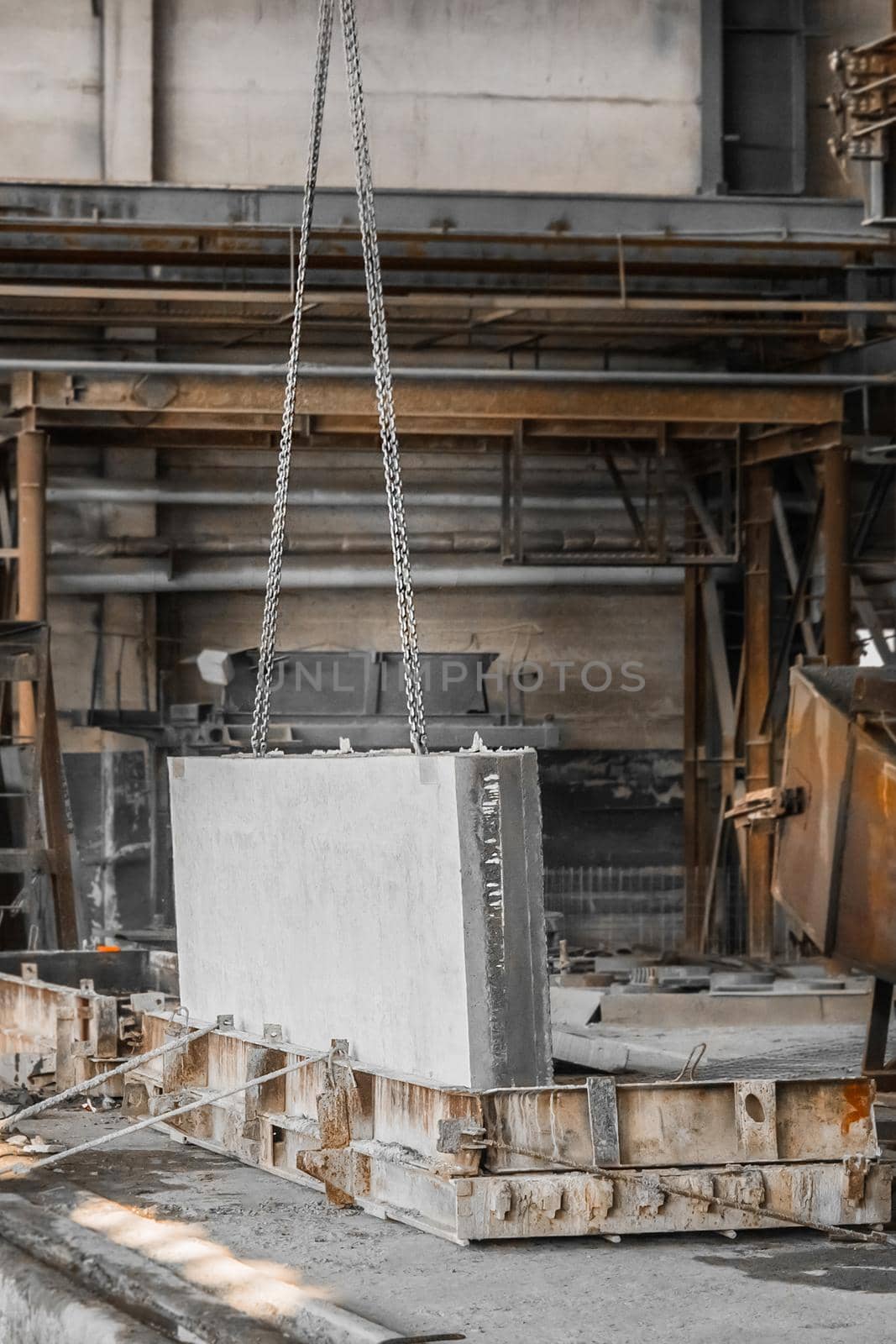 A large concrete plate on a lifting mechanism with a chain in the reinforcement production of an industrial enterprise by AYDO8