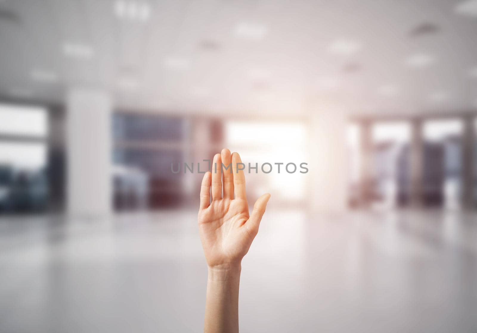Close of woman hand touching screen with palm and office at background