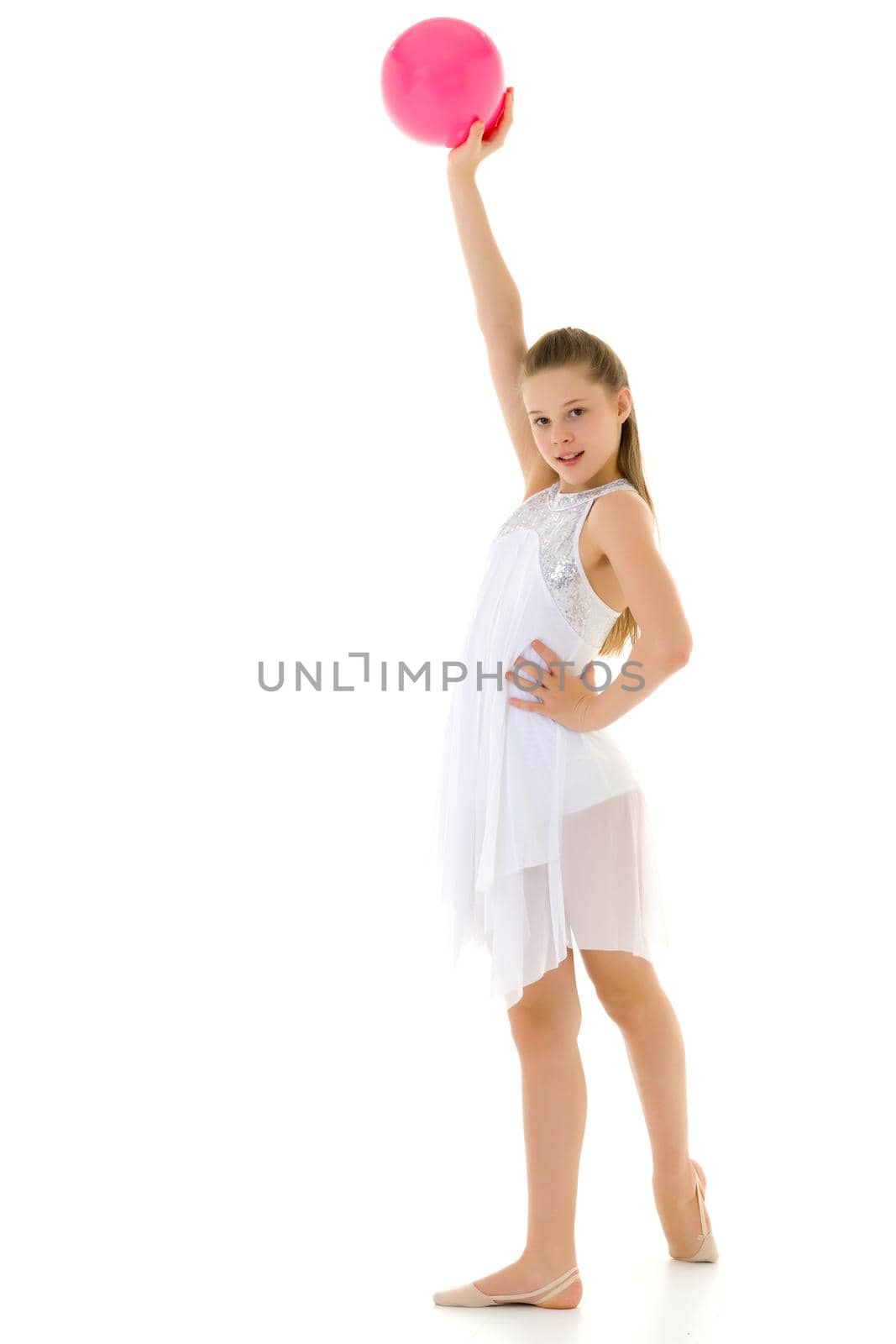 Beautiful little girl gymnast performs exercises with the ball. The concept of children's sports, fitness. Isolated on white background.