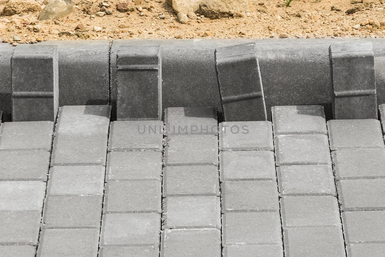 Laying floor tile sidewalk urban road or repairing paving stone slabs at a construction site.