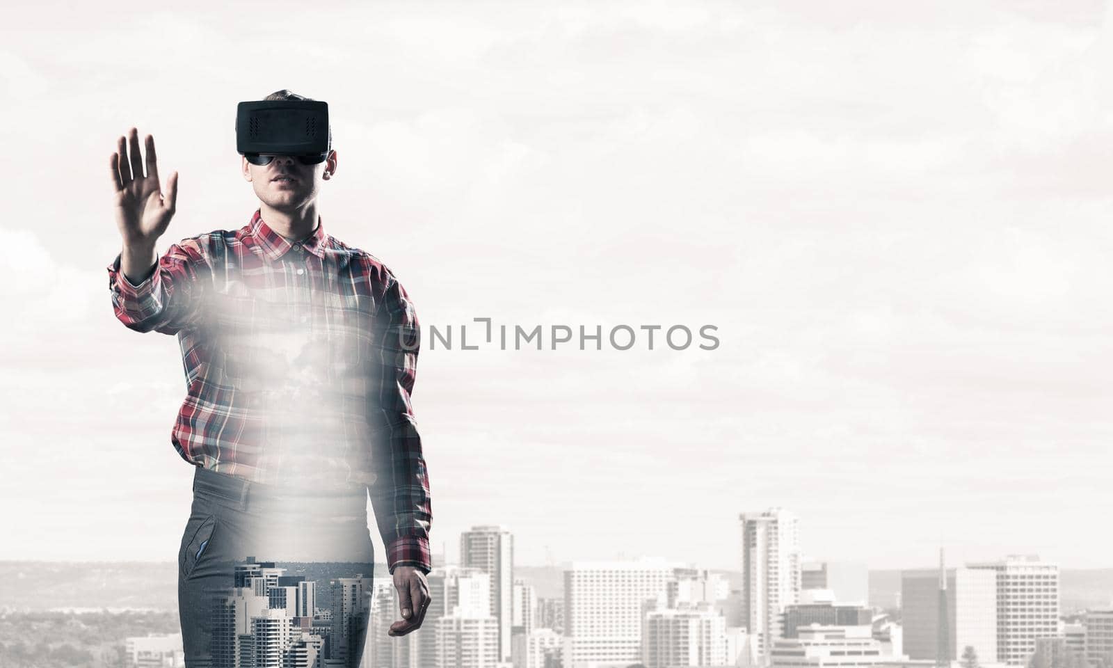 Young man with virtual reality headset or 3d glasses over cityscape background