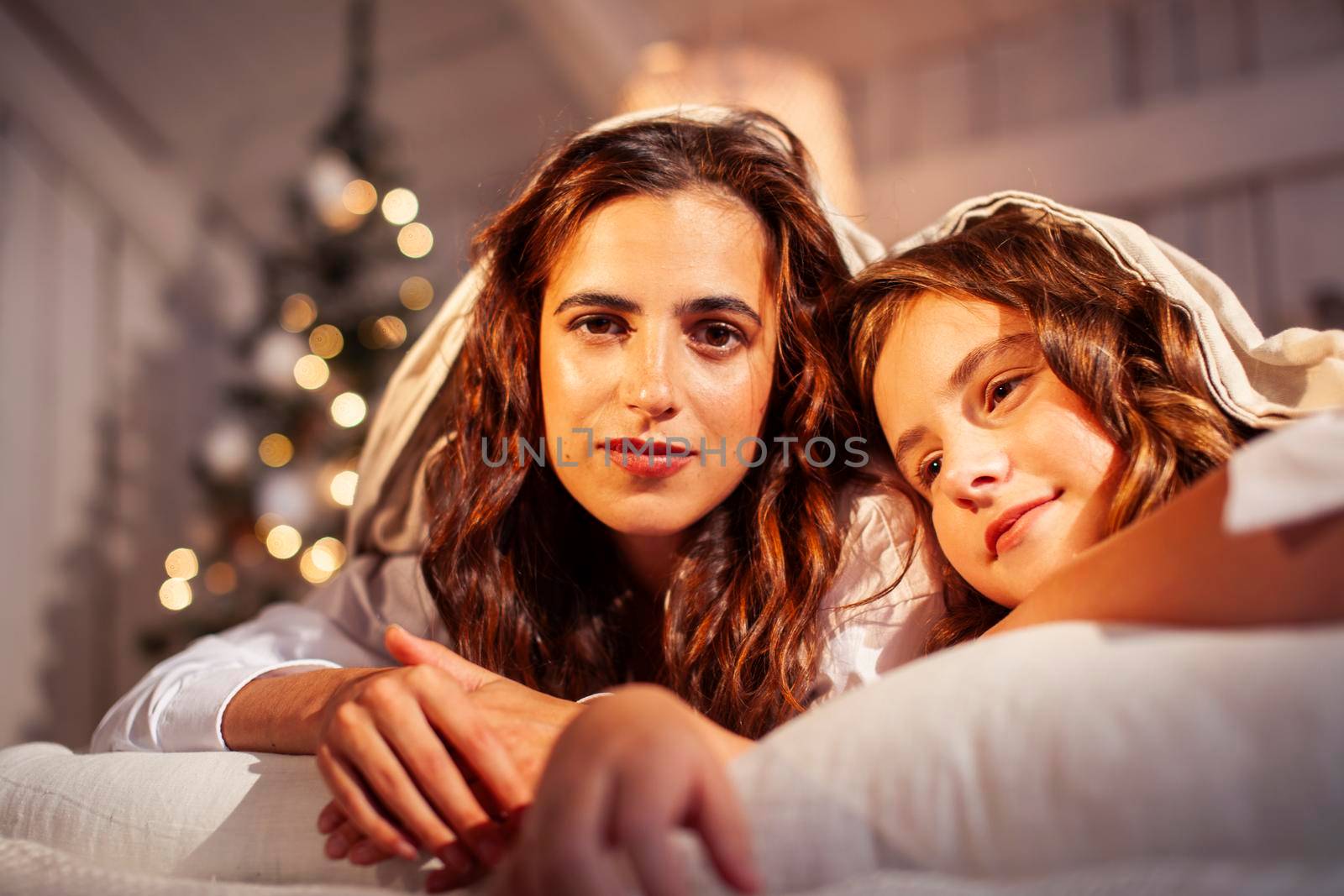 young pretty girls in bed at Christmass morning, happy family smiling lifestyle at holiday close up