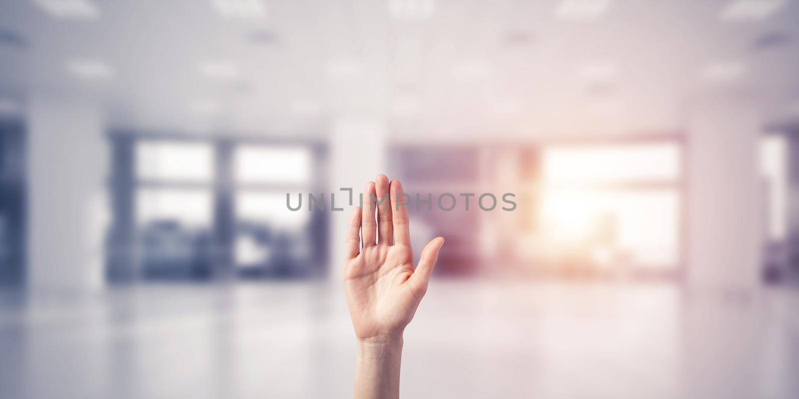 Close of woman hand touching screen with palm and office at background