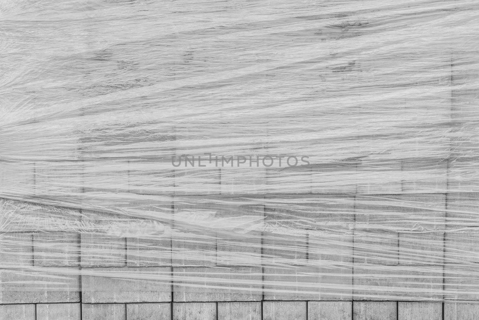 A pile of new paving stone slabs wrapped in plastic wrap background. Building tile materials at the construction site by AYDO8