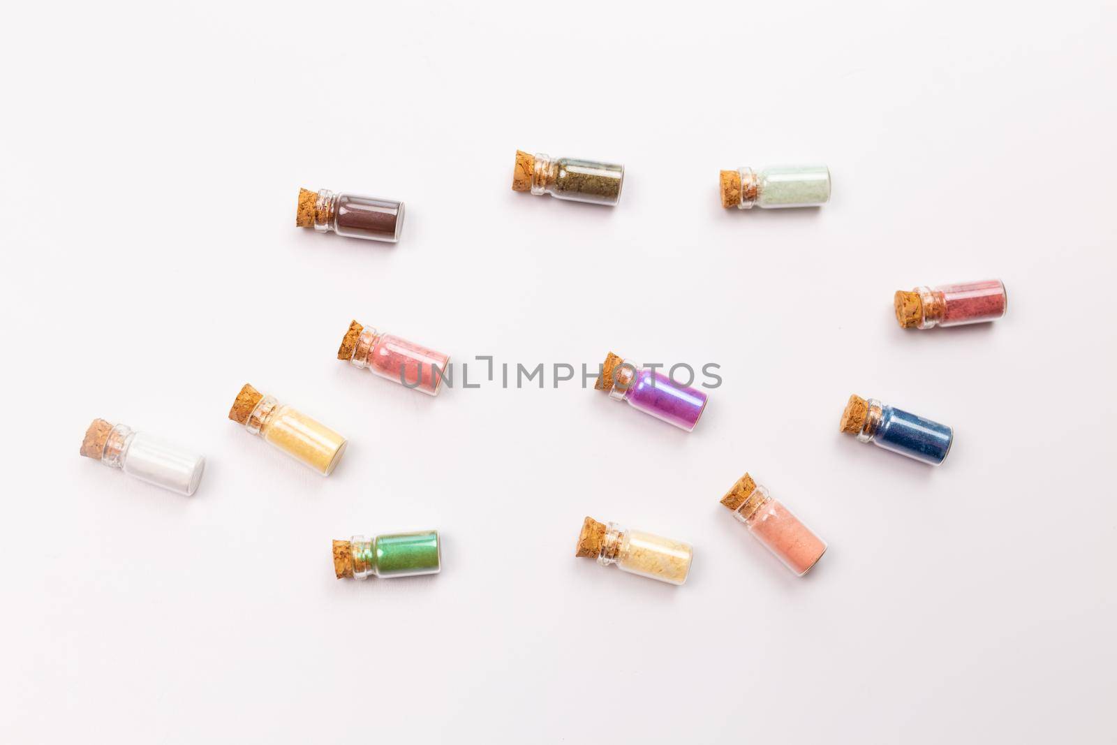 Cosmetics, makeup and beauty concept - Colourful eye shadow in small glass boxes on white background, top view close up