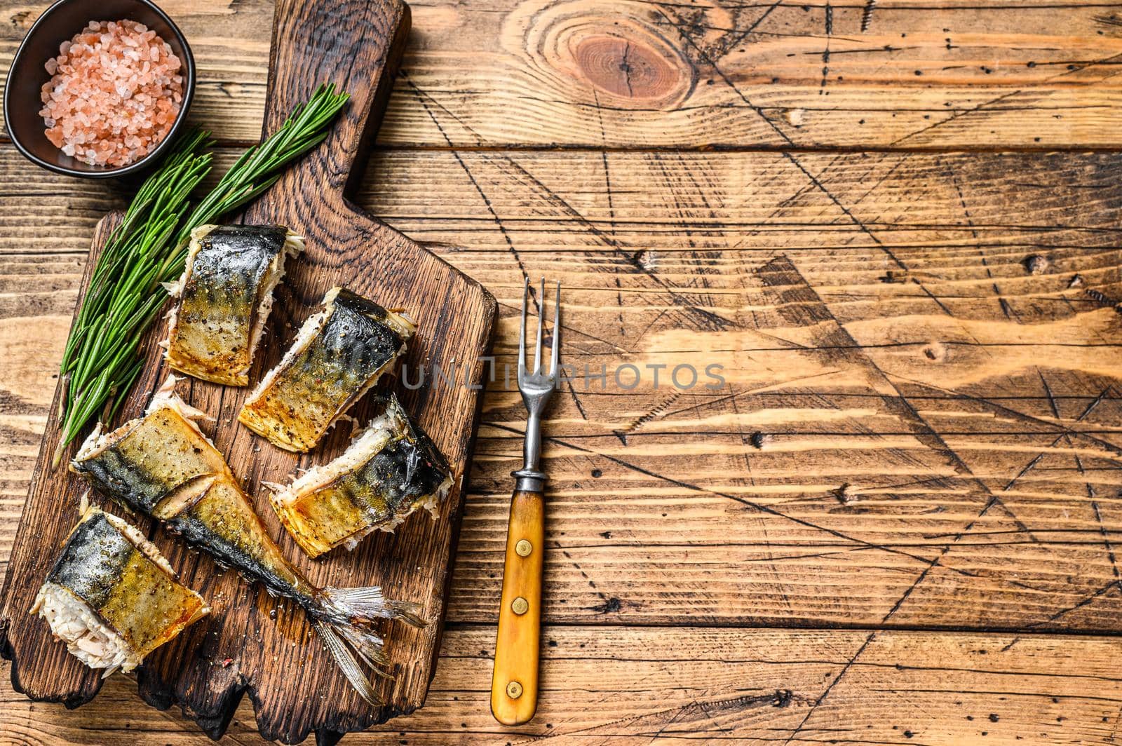 Grilled cut mackerel fish on cutting board. wooden background. Top view. Copy space.